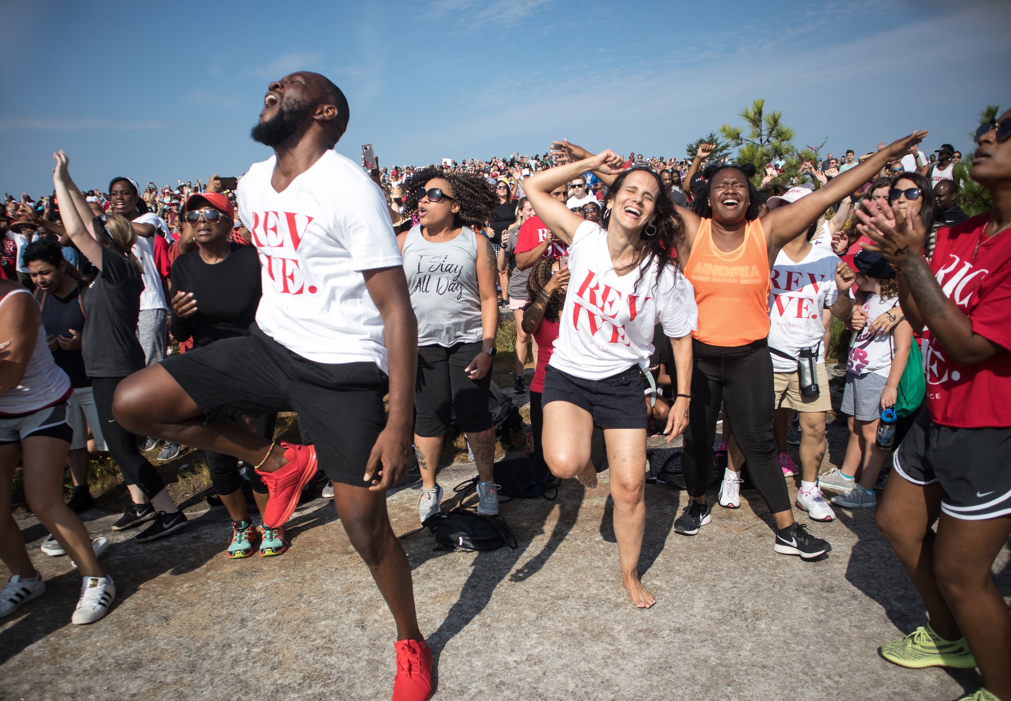 David Bryant (L) and Adelaide Leao (C) worship together during the start of the OneRace event on top of Stone Mountain Saturday.