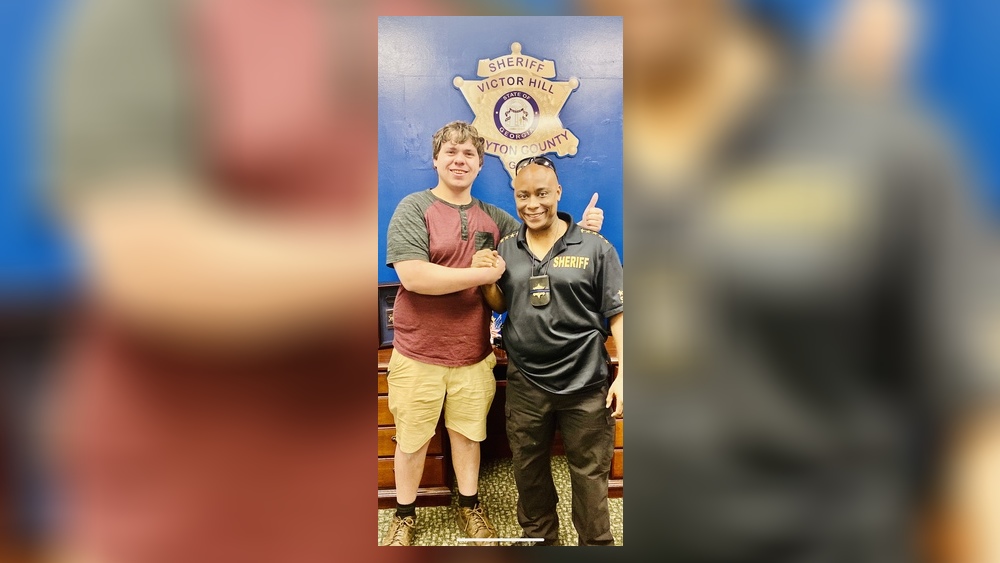 Clayton County Sheriff Victor Hill poses with Joseph Chilton, a bread delivery man who shot a robbery suspect at a Hardee's on Saturday morning. Chilton was named an “honorary deputy” by the sheriff.