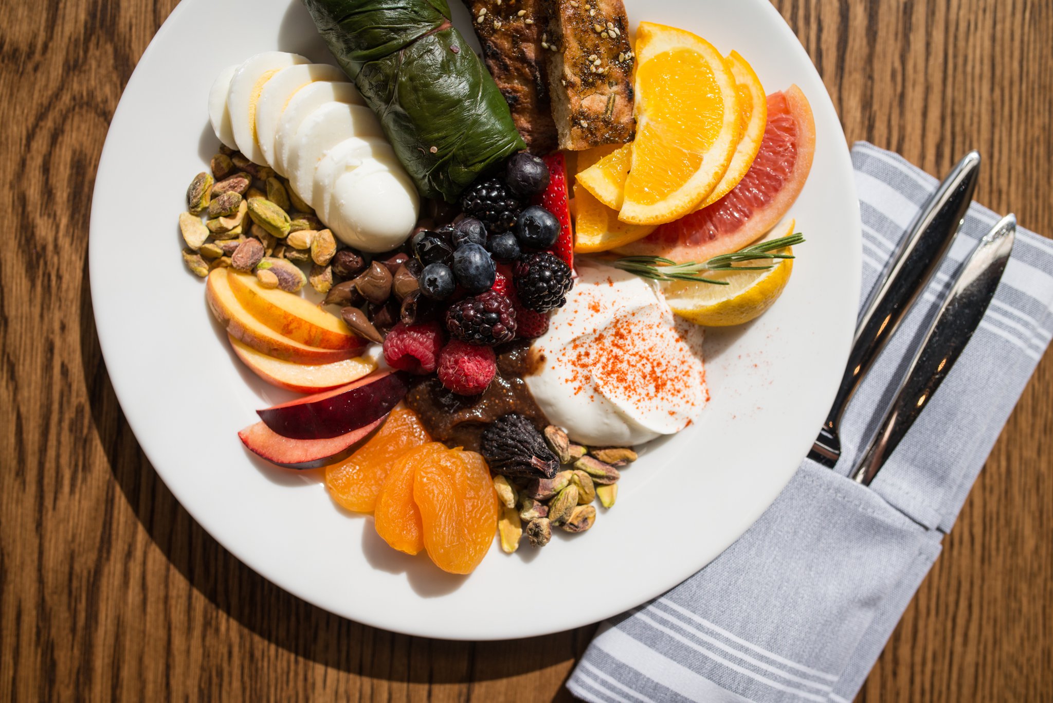 Mediterranea Mediterranean Breakfast with fresh fruit, dried fruit, nuts, dolmas, hard cooked egg, yogurt , fig compote, and seasoned bread. Photo credit- Mia Yakel.