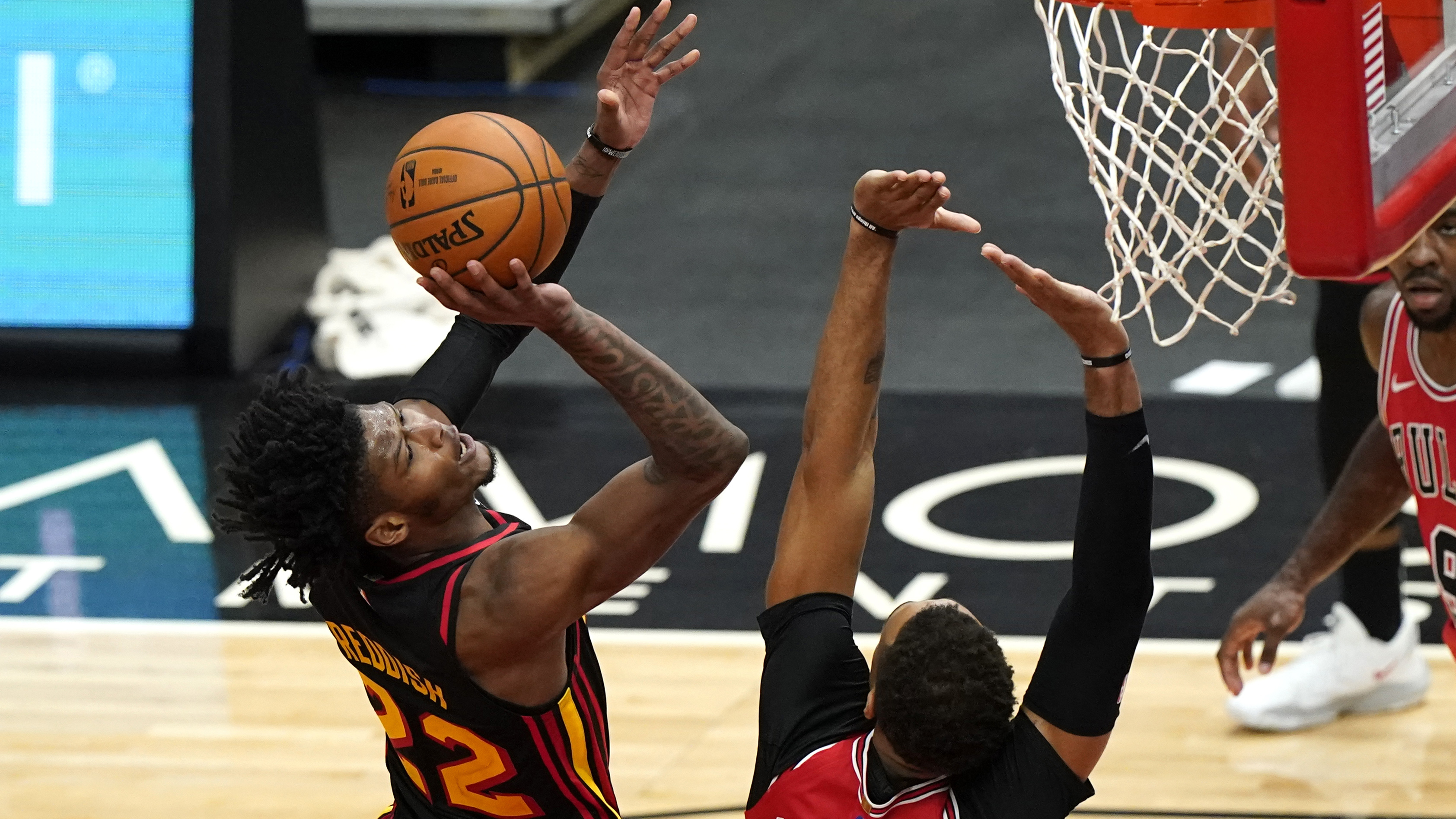 Hawks' Cam Reddish (left) shoots against the Bulls' Daniel Gafford during the second half of the season opener Wednesday, Dec. 23, 2020, in Chicago. (Nam Y. Huh/AP)