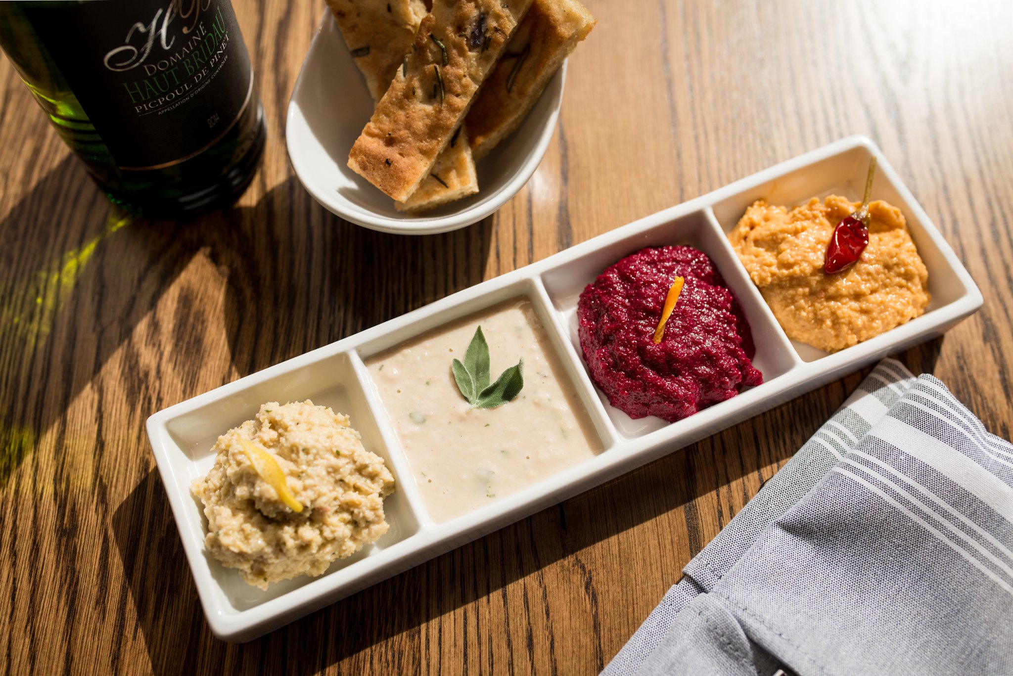 Mediterranea Quartet of Spreads with lemon artichoke, savory white bean, orange beet, and Calabrese chickpea spreads. Photo credit- Mia Yakel.
