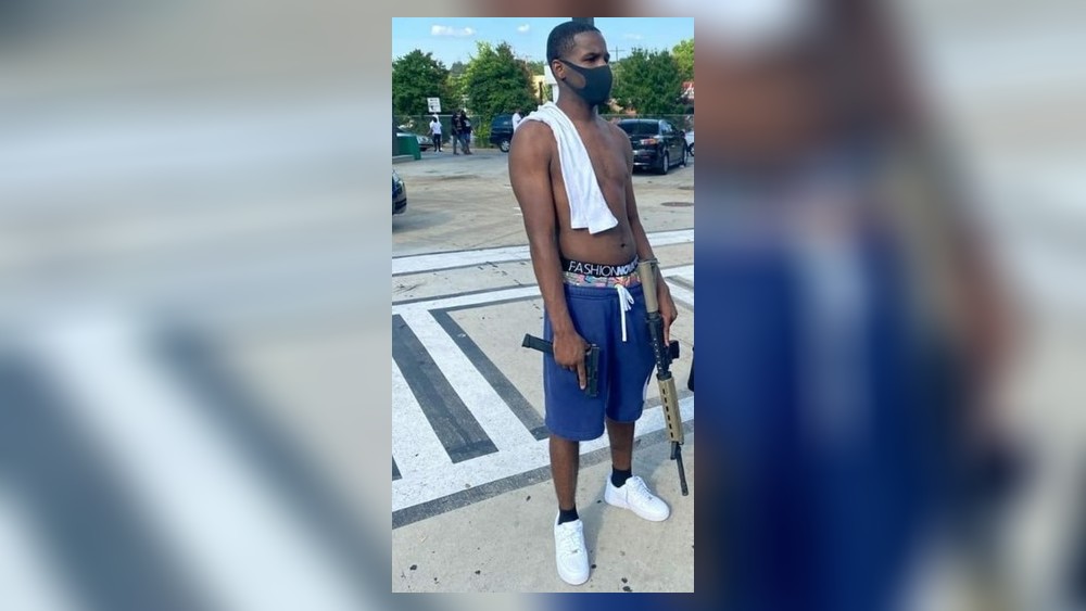 The man seen holding two guns is a person of interest in the shooting death of 8-year-old Secoriea Turner, police said.