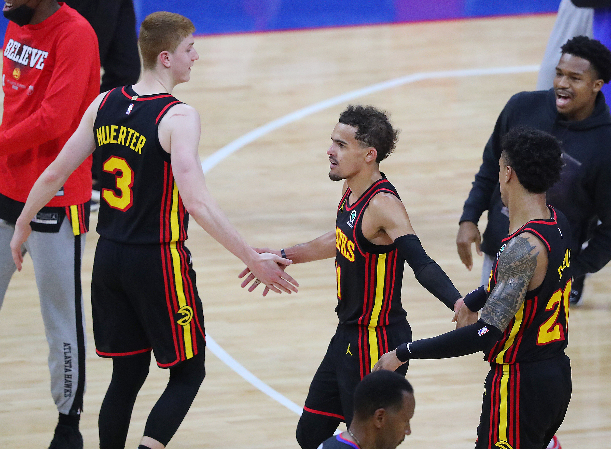 Hawks guards Kevin Huerter (left), Trae Young (center), and forward John Collins celebrate the 103-96 victory over the Philadelphia 76ers in Game 7 of the Eastern Conference semifinals Sunday, June 20, 2021, in Philadelphia. (Curtis Compton / Curtis.Compton@ajc.com)