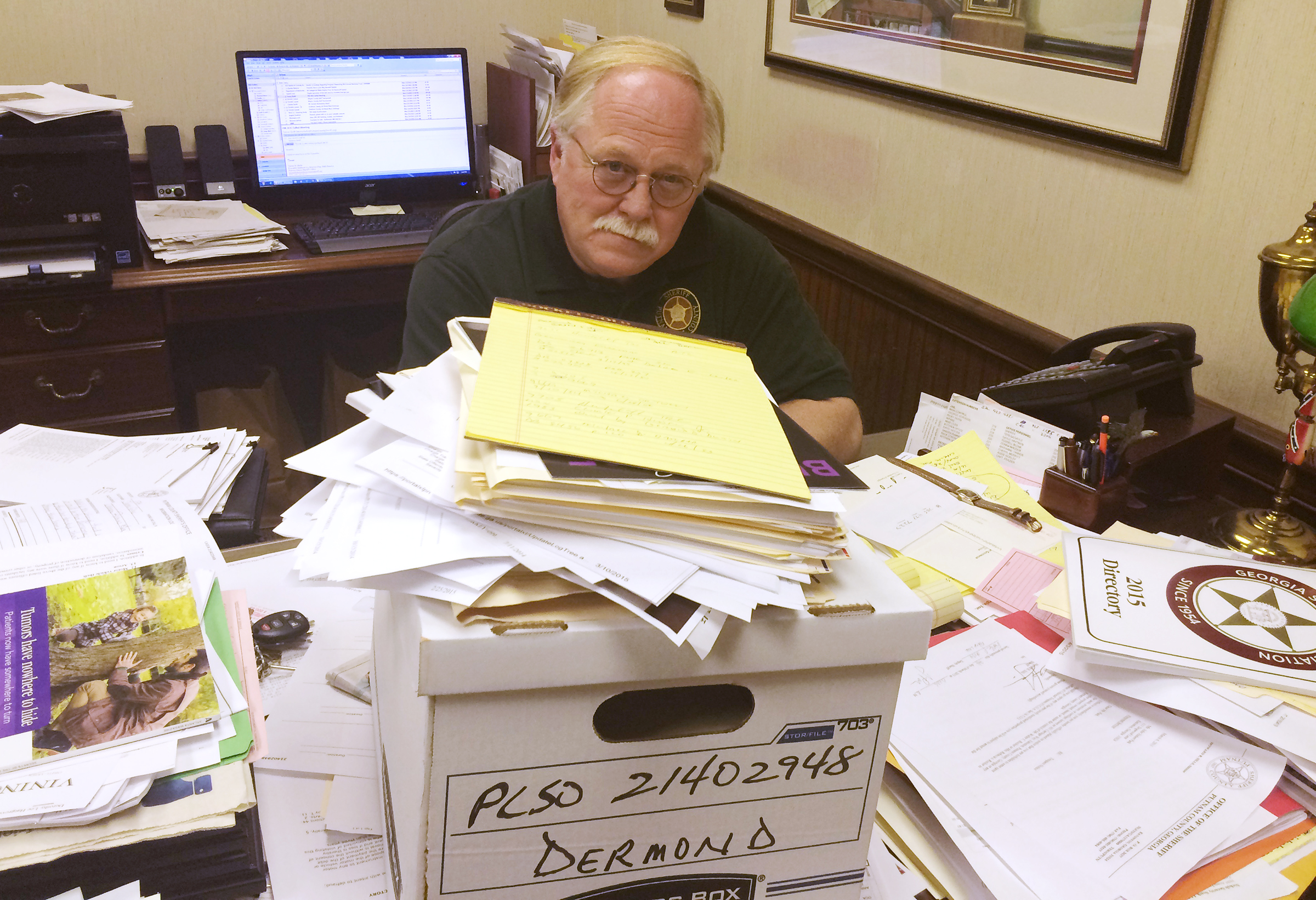 In 2015, a year after the deadly crimes, Putnam County Sheriff Howard Sills inspects the already collected documents related to the murders of Russell and Shirley Dermond. (Photo: Christian Boone/AJC)