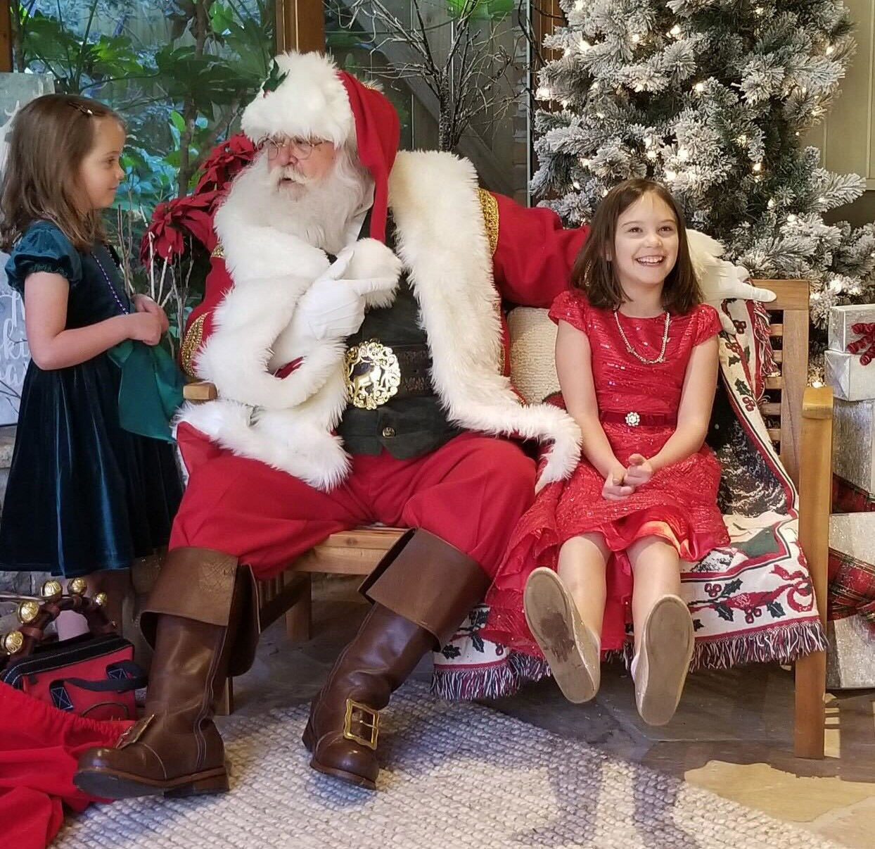 Marian Dudley (red dress) and Evelyn (green dress), the daughters of Denice and Phillip Dudley, recently went to an outdoor Santa visit in their neighborhood. (Submitted photo)