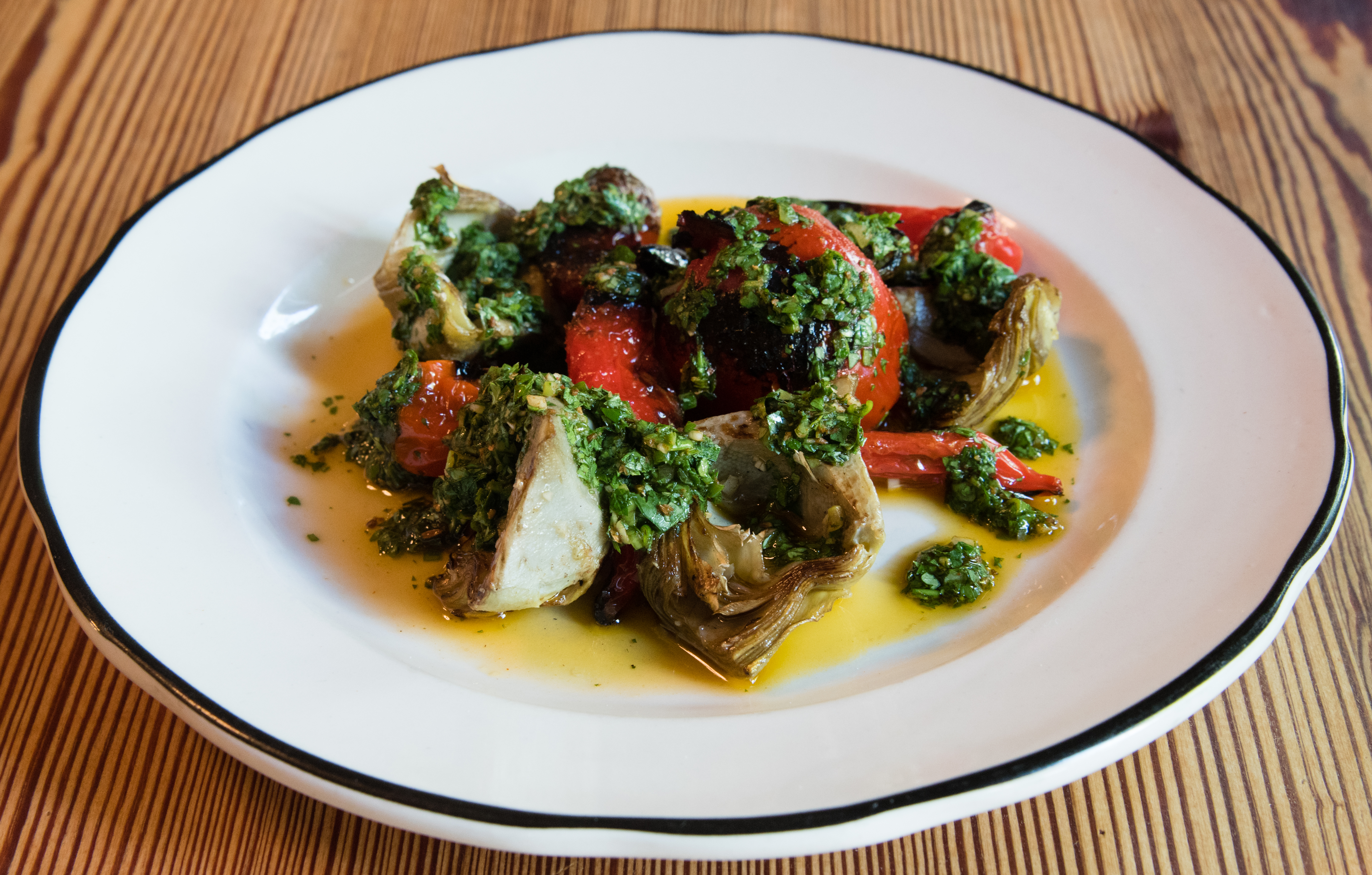 Cakes + Ale pairs artichokes with nardellos, a sweet Italian pepper, as well as roasted tomato and green harrissa. / CONTRIBUTED BY HENRI HOLLIS