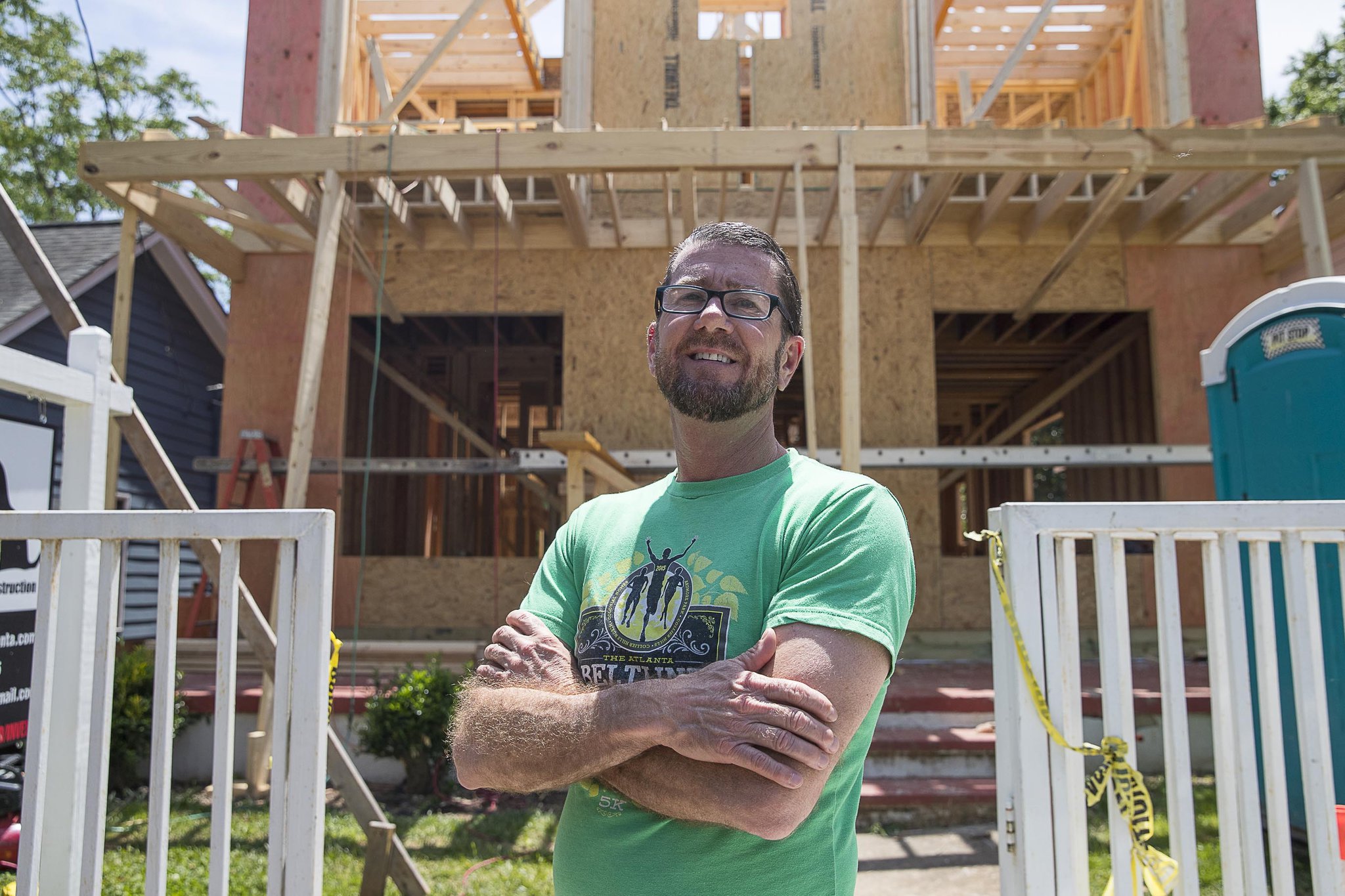 Michael Looney talks about the changing landscape of his block while standing in front of his newly constructed residence in Atlanta’s Old Fourth Ward community. Michael and his family moved from Gwinnett County to the intown neighborhood about five years ago. The one-story house that they purchased is now being reconstructed into a two-story house. (ALYSSA POINTER/ALYSSA.POINTER@AJC.COM)