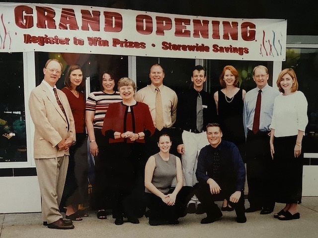 Jean Mori, left, and his wife Betty, fourth from left in the red jacket, at the grand opening of one of their Mori Luggage & Gifts stores.