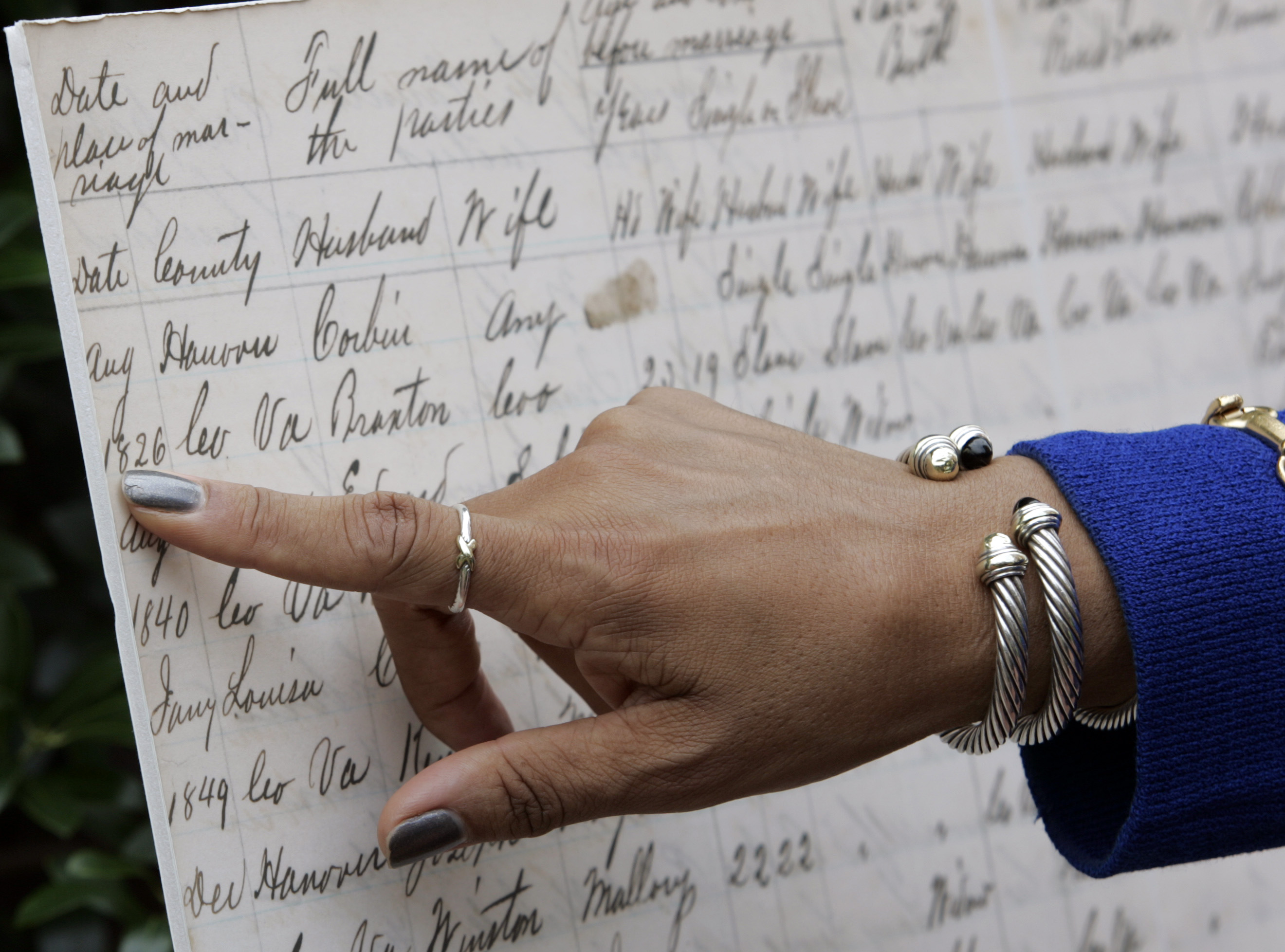 Virginia Secretary of Administration, Viola Baskerville, points out court records that were used to help trace her geneology after a press conference in front of the Black History Museum and Cultural Center of Virginia in Richmond, Va., Thursday, July 9, 2009. Gov. Tim Kaine announced the online availability of the Virginia Freedman's Board records. Steve Helber/AP