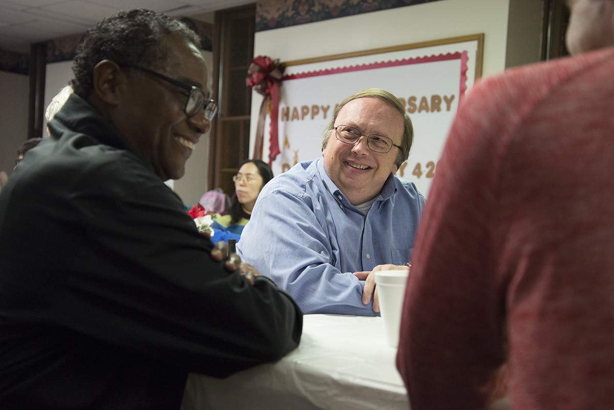 Darrell Pursiful, of First Baptist Church of Christ on High Place, talks to Alveno Ross, a deacon at First Baptist Church on New Street, after eating Thanksgiving Potluck at First Baptist Church on Sunday, Nov. 19. (Jenna Eason / for the AJC)