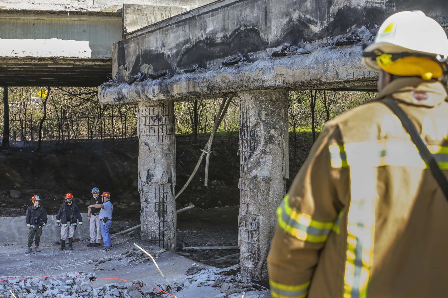 Atlanta firefighters remained on the scene putting out a smoldering fire Friday, March 31, 2017 at the I-85 collapse site while construction crews made their way into the zone to begin work.