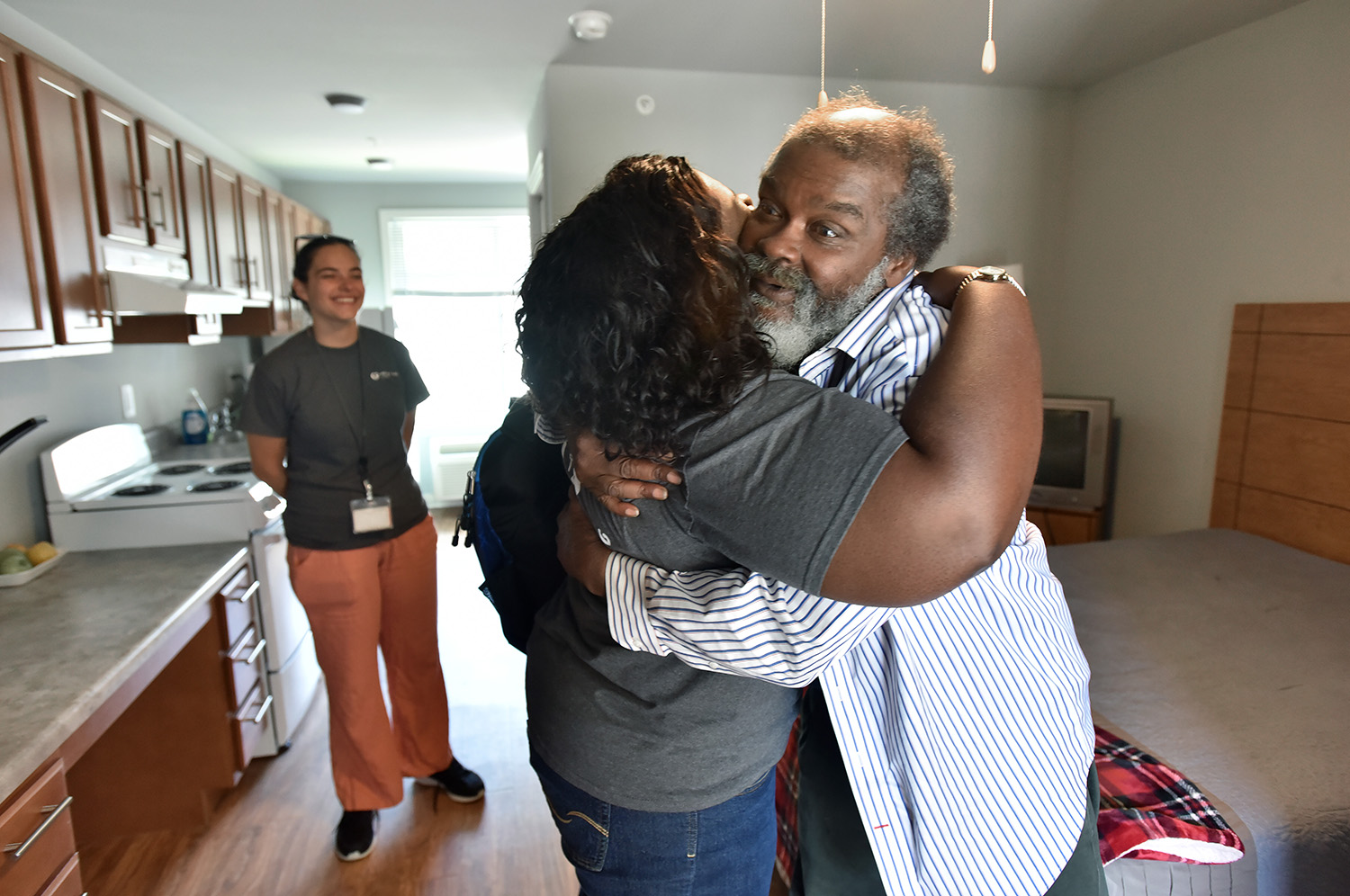 Stephanie Dotson gets a hug from her client Willie Franks, right, as Mercy Care street medicine team members visit to check their clients at Phoenix House, affordable housing complex reserved for the homeless and mentally disabled, in Atlanta. (Hyosub Shin / Hyosub.Shin@ajc.com)