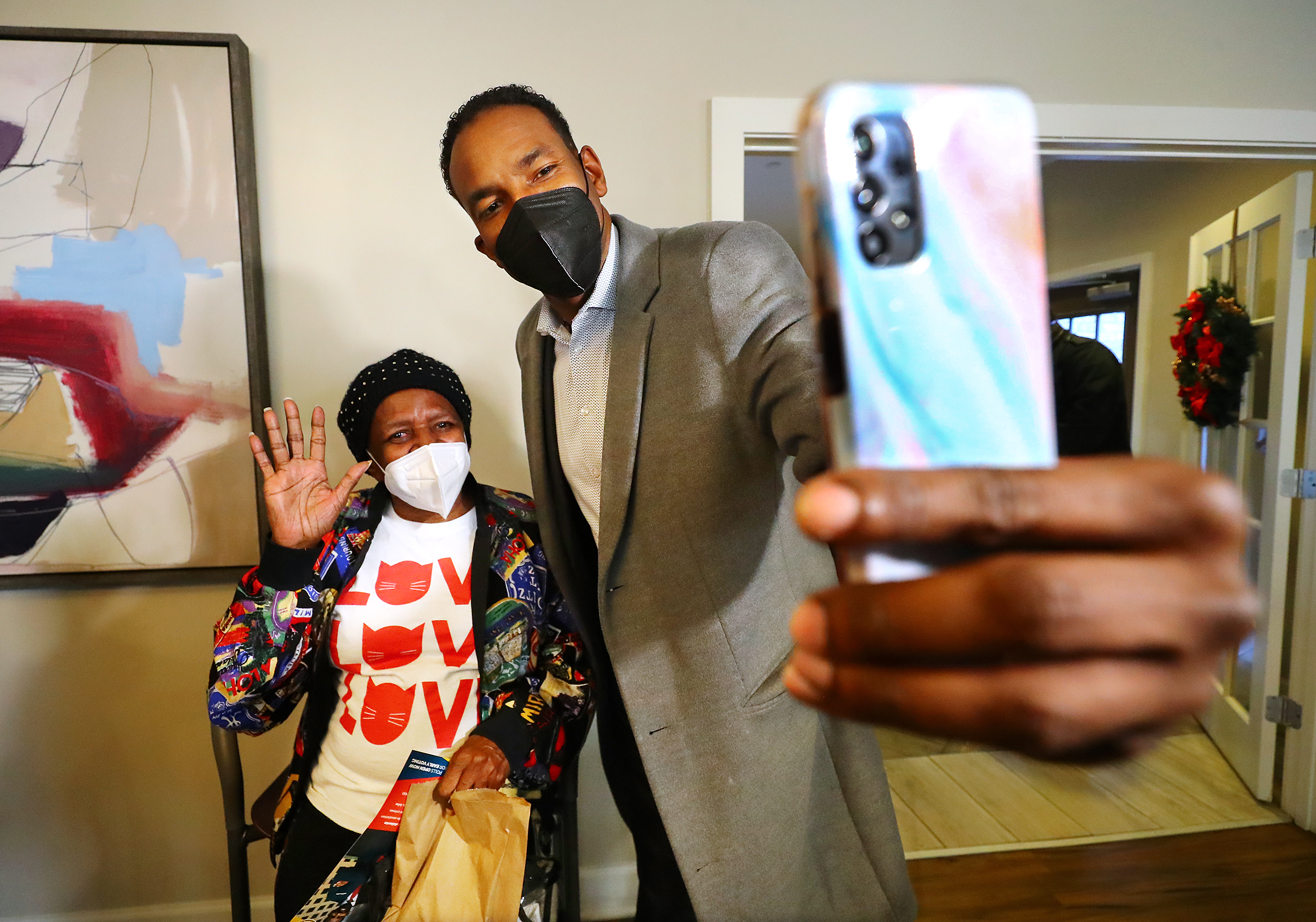 Atlanta mayoral candidate and councilman Andre Dickenson pauses for a selfie with Yolanda Napier while visiting with her and other residents during a campaign stop at The Remington, a senior living facility, on the eve of the mayoral runoff election on Monday, Nov. 29, 2021, in Atlanta. “Curtis Compton / Curtis.Compton@ajc.com”`