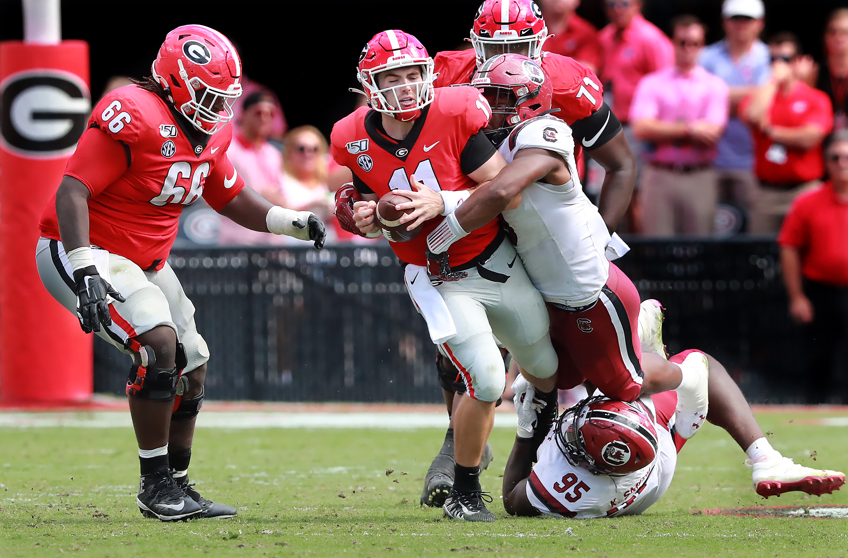 Georgia quarterback Jake Fromm is sacked by South Carolina defenders Kobe Smith (bottom) and D.J. Wonnum (top) during the third quarter in a NCAA college football game on Saturday, October, 12, 2019, in Athens. Curtis Compton/ccompton@ajc.com