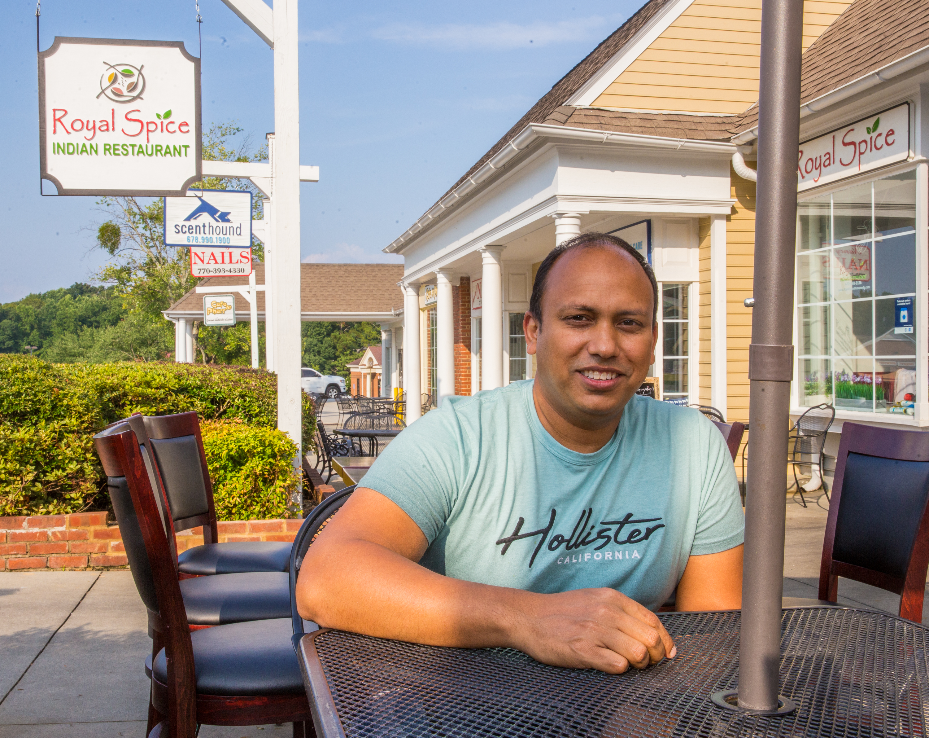 Dunwoody Village businesses, including Royal Spice, may soon have a new city center, in the mean time the locals enjoy whatever green space and outdoor patios they can find in the multiple shopping complexes patched together in the area on Thursday, July 22, 2021. Junayed Ahmed owns Royal Spice and just celebrated their first year June 1; part of his concern is visibility with shrubbery, recessed store fronts and the outdated signage, which makes it easy to pass by. (Jenni Girtman for The Atlanta Journal-Constitution)