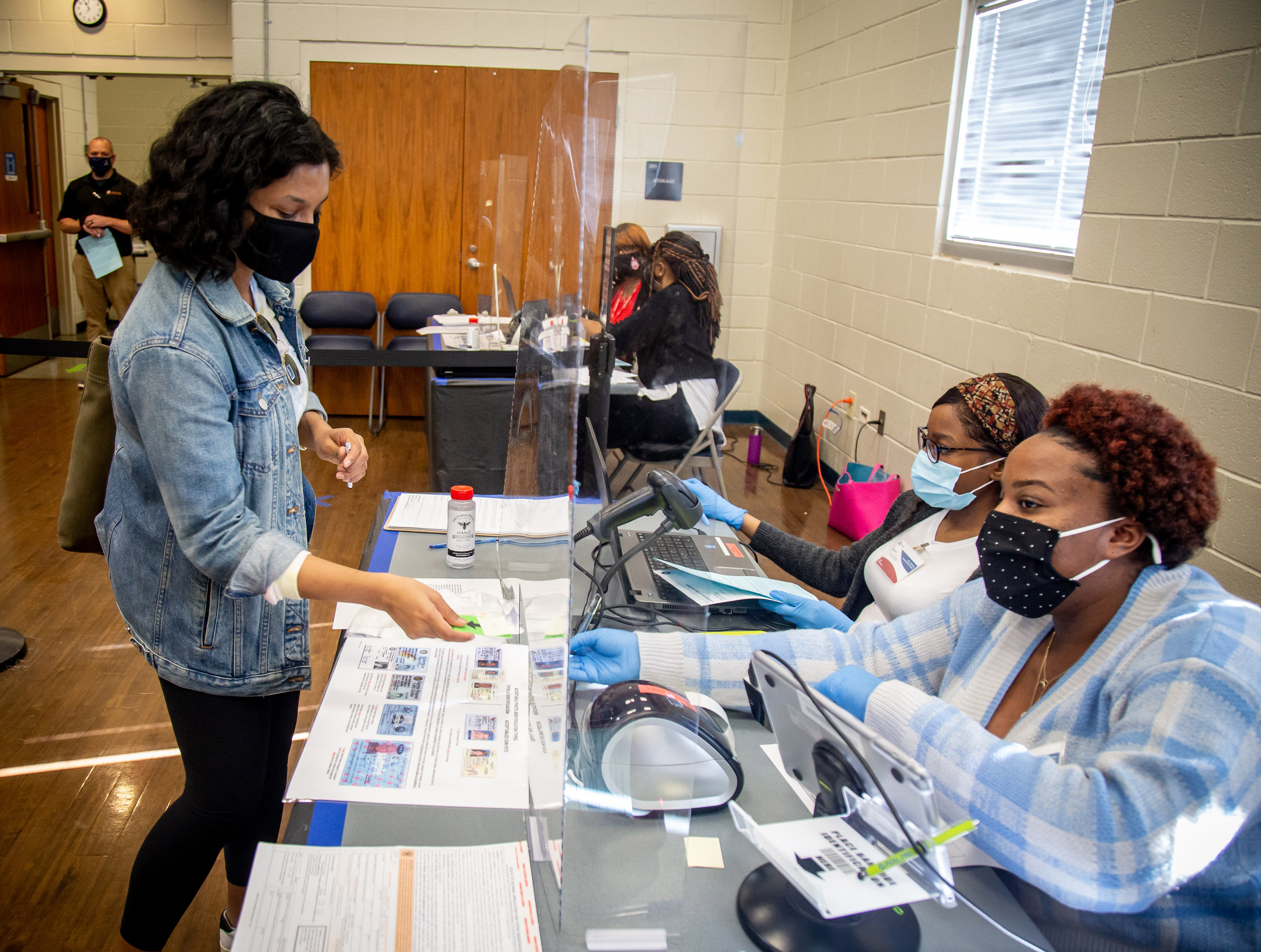Khyati Sehgal gets her paperwork before casting her vote in Gwinnett on October 23, 2020. STEVE SCHAEFER / SPECIAL TO THE AJC