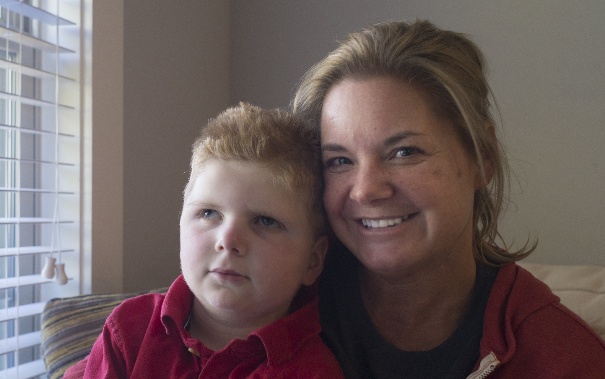 Tripp Halstead, 7, and Stacy Halstead pose for a portrait last month in their home in Jefferson, Ga. Tripp, who suffered a traumatic brain injury five years ago when a tree limb fell on him at his day care, was rushed to the hospital Monday. He was expected to retrun home Wednesday. (CASEY SYKES, CASEY.SYKES@AJC.COM)