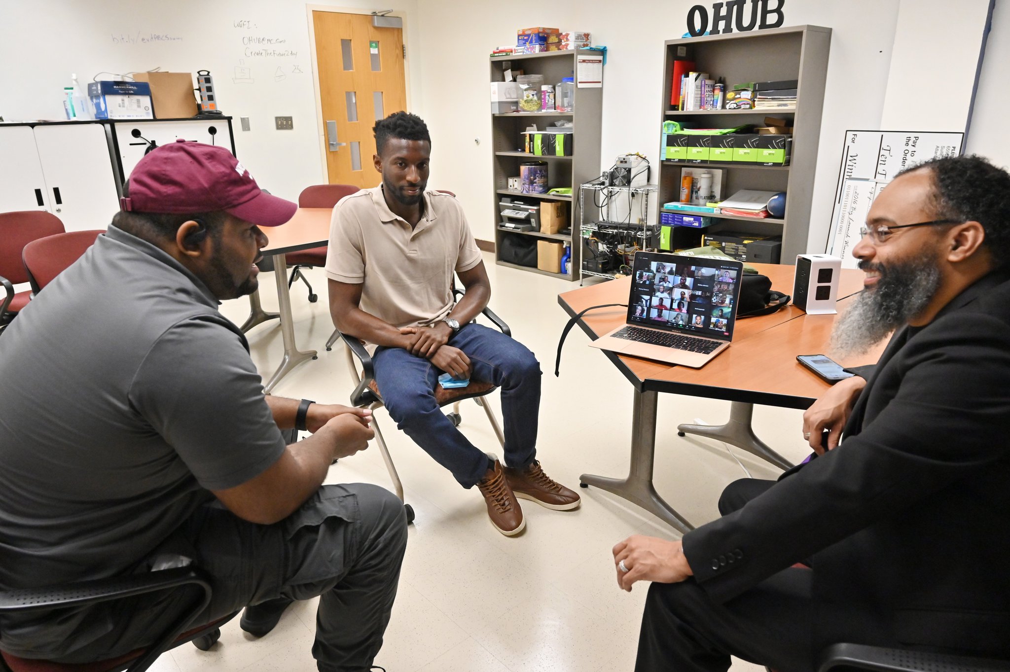 Kinnis Gosha (left), the Hortinius I. Chenault Endowed Division Chair for Experiential Learning and Interdisciplinary Studies, and Rodney Sampson (right), chairman & CEO of OHUB, speak to Morehouse student Corey Shaw during an online coding boot camp created by Morehouse College in 2020. The college started an online education program in 2021. (HYOSUB SHIN / HYOSUB.SHIN@AJC.COM)