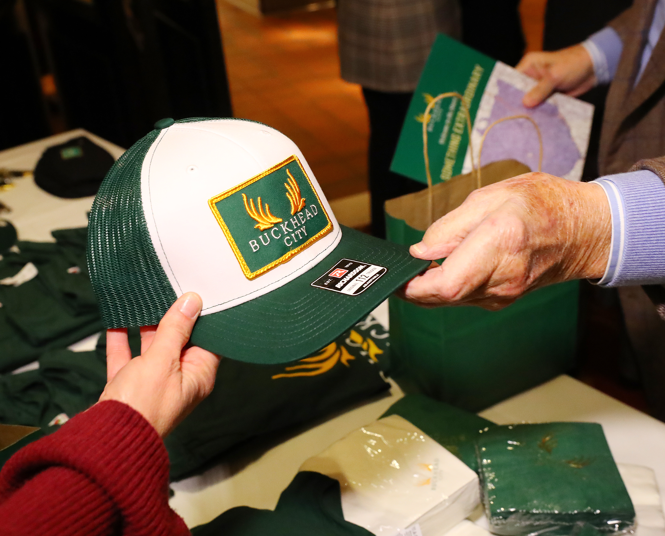 A supporter buys a Buckhead City hat as he arrives for a Buckhead cityhood movement fundraiser last month at Bistro Niko. Some critics have questioned whether money is motivating the activism of Bill White, but White insists he’s not being paid for his work. (Curtis Compton / Curtis.Compton@ajc.com)