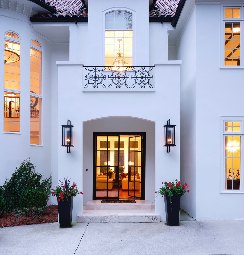 "We took a heavy, dark and foreboding entrance and make it light, bright and inviting. Changing the front doors to the steel and glass, changing the flooring to a lighter stone and painting the outside home a more neutral color lightened the mood of the entrance."