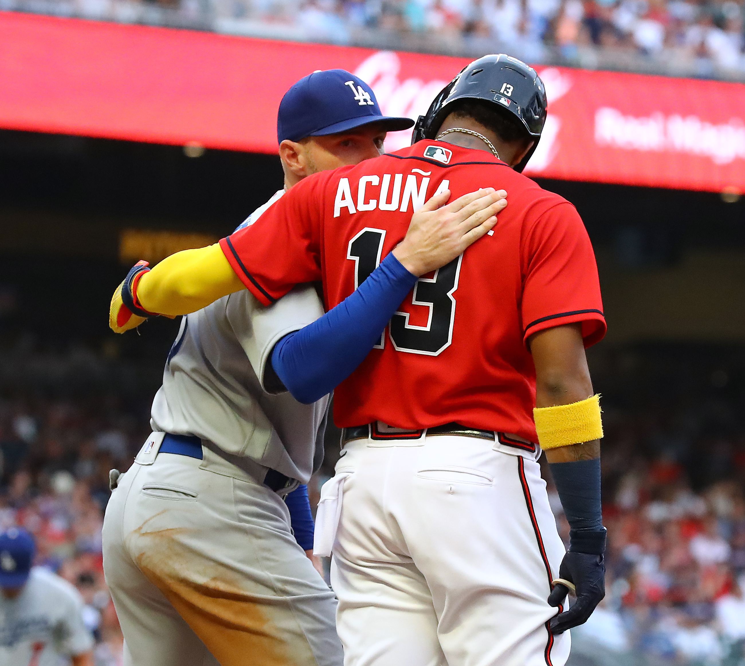 Braves outfielder Ronald Acuna gets a hug from Los Angles Dodgers first baseman Freddie Freeman after drawing a walk during the first inning in a MLB baseball game on Friday, June 24, 2022, in Atlanta.   “Curtis Compton / Curtis.Compton@ajc.com”