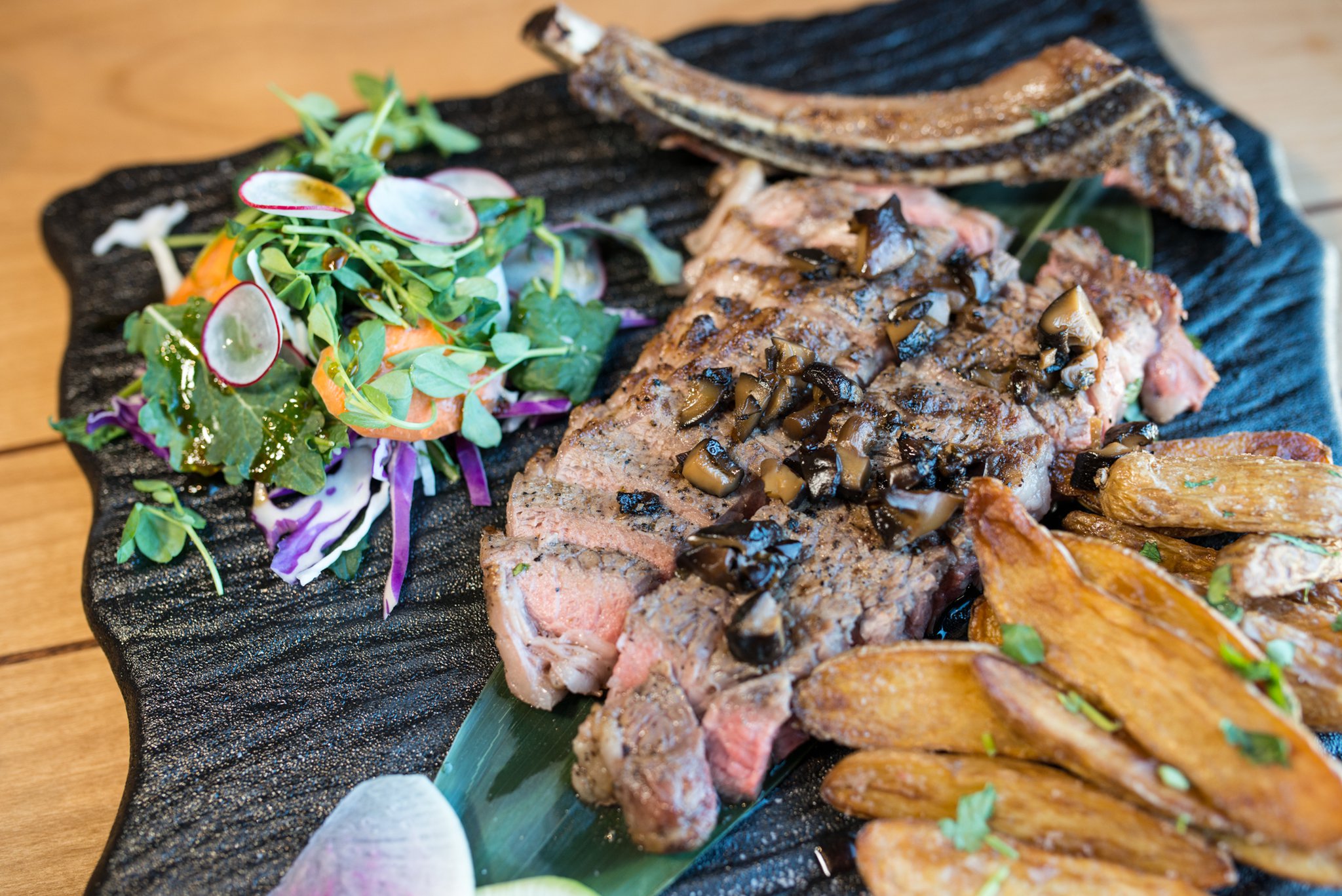 Hopstix Hopsteak, 16-ounce bone-in ribeye with shiitake-mushroom-wasabi butter and fingerling potatos. Photo credit- Mia Yakel.