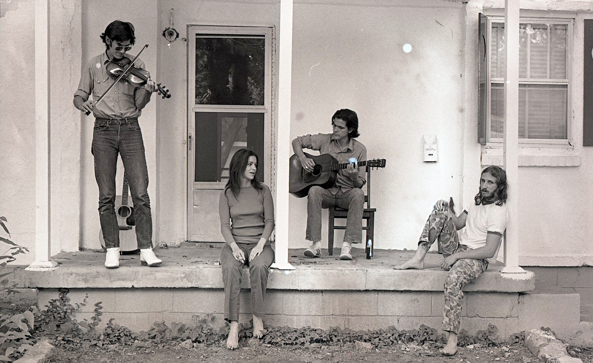 Musicians Townes Van Zandt (from left), Susanna Clark, Guy Clark and Daniel Antopolsky play some tunes on the Clarks’ porch in Nashville in 1972. (Courtesy of Al Clayton)
