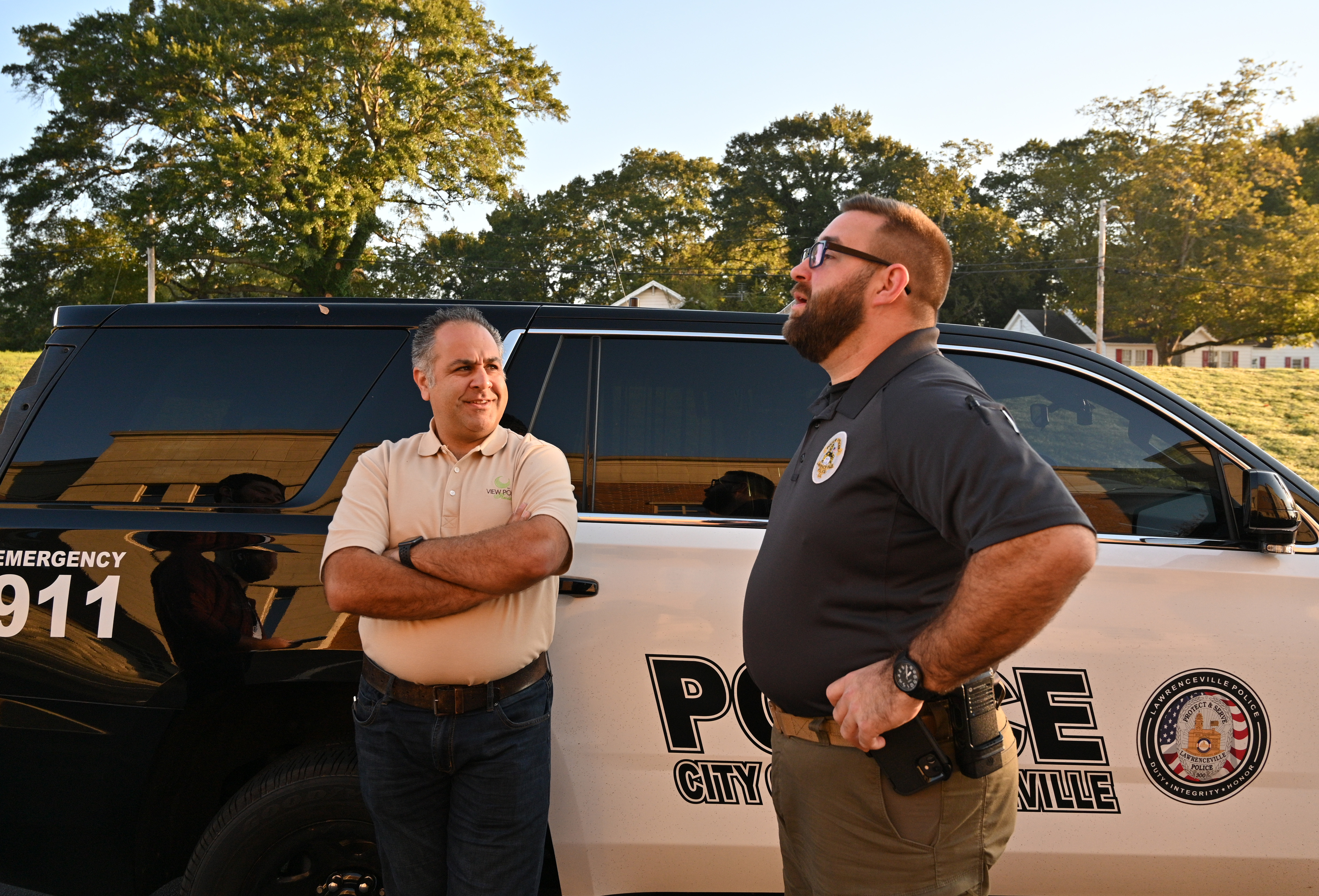 A 2021 image of Pej Mahdavi, behavioral health clinician with View Point Health talking Officer Jacob Baird in the parking lot of the Lawrenceville Police Department. Mahdavi is one of the behavioral health clinicians who assists officers with mental health crises. (Hyosub Shin / Hyosub.Shin@ajc.com)
