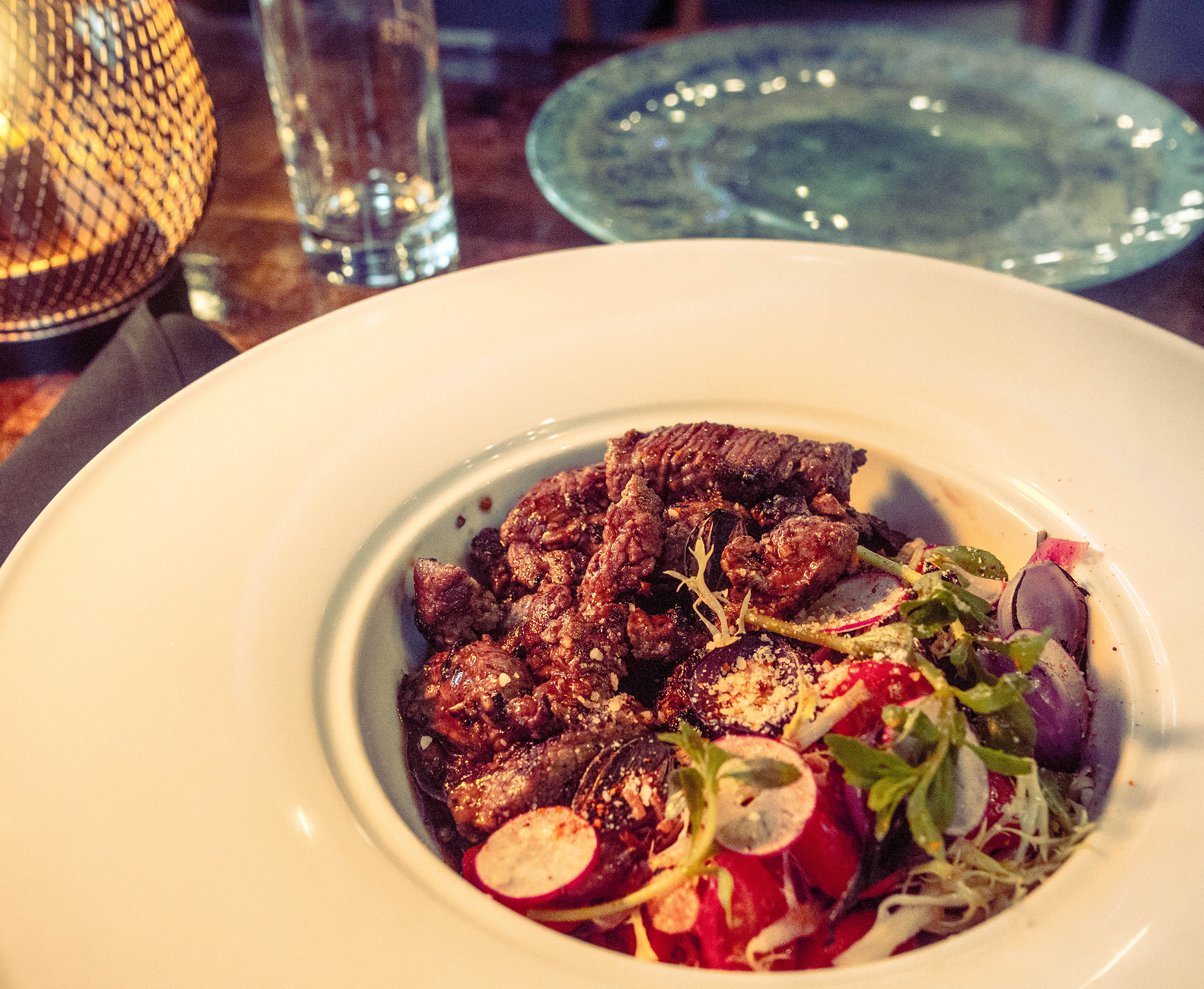 Shaking Beef 8-ounce filet mignon with frisée salad and marinated tomatoes.
Courtesy of Girl Diver