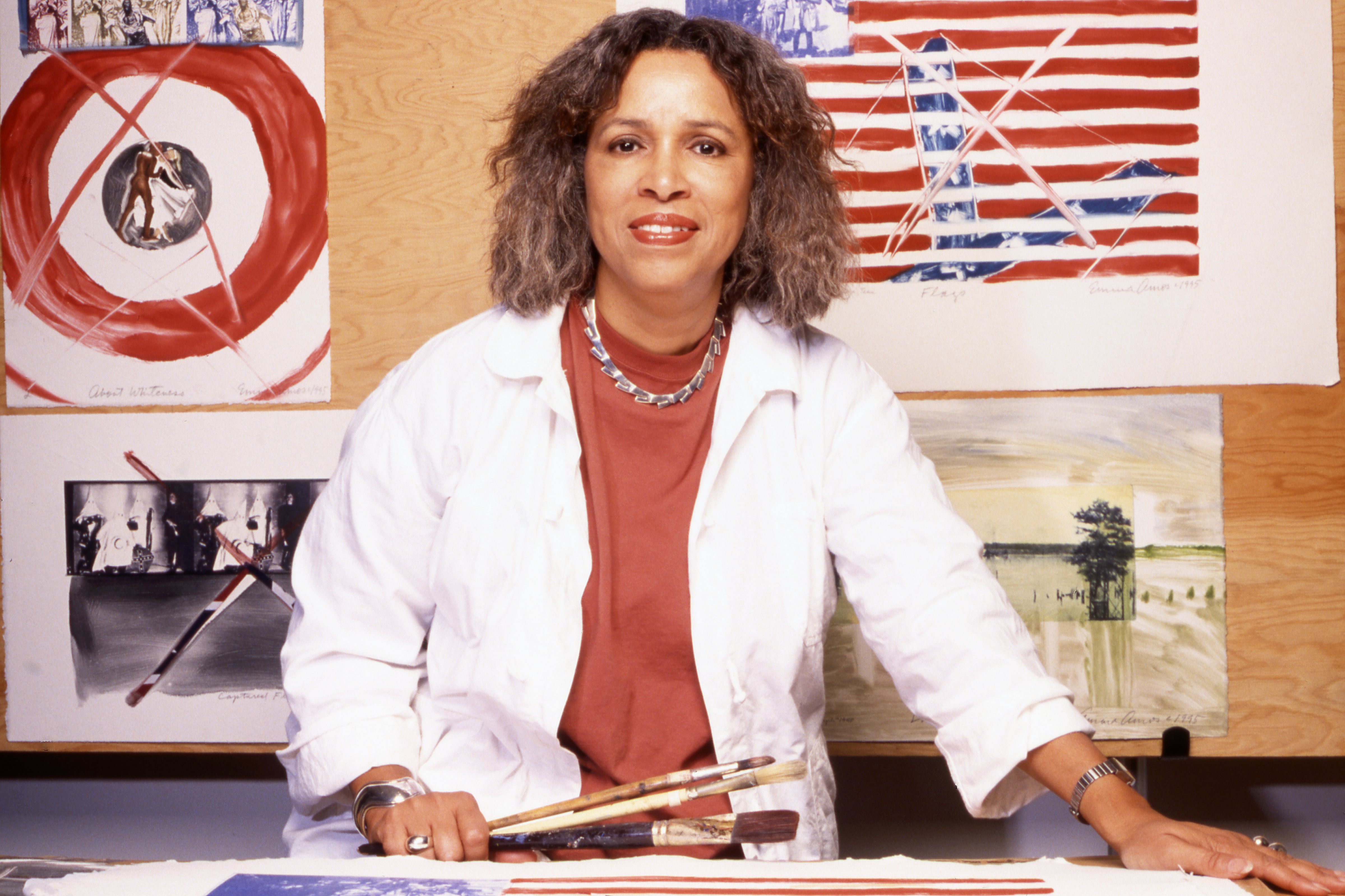 The new Georgia Museum retrospective: "Emma Amos: Color Odyssey," opens on Jan. 30, in Athens. Amos, born in Atlanta, used her career to challenge ideas around race, sex, and class. Behind her is a version of her piece "About Whiteness." Amos died in 2020 from complications due to Alzheimer's disease.