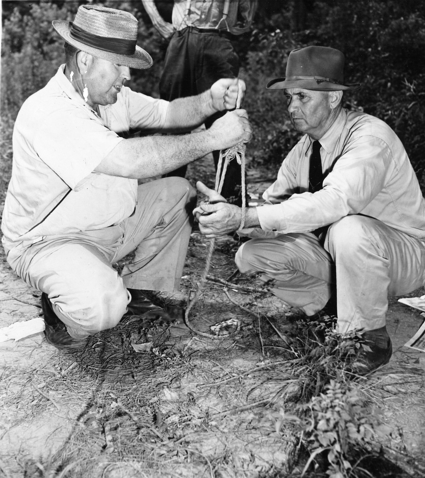 Loy Harrison (left), Oconee County farmer, shows Sheriff J.M. Bond of Oconee County how a mob of white men bound the hands of two black men together before shooting them and their wives to death near Monroe, Ga. in 1946. Harrison said the mob took the black couples from his car as he was driving to his farm. Harrison, the only known eyewitness to the time of the killings, was a suspect, but no one was ever charged.(Associated Press Photo)
