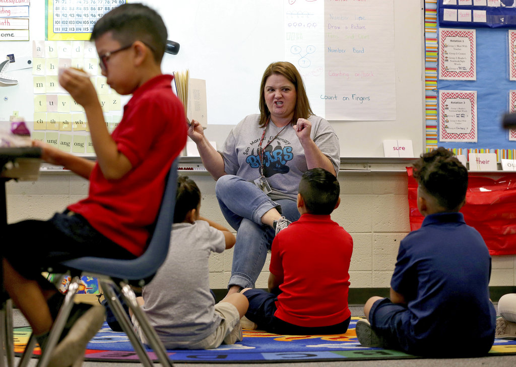 Third grade teacher Jennifer Boettcher reads a story to kids as they eat breakfast at San Marcos Elementary School Friday, May 4, 2018, in Chandler, Ariz., after a statewide teachers strike ended. The week of May 7-12 is National Teacher Appreciation Week. (AP Photo/Matt York)