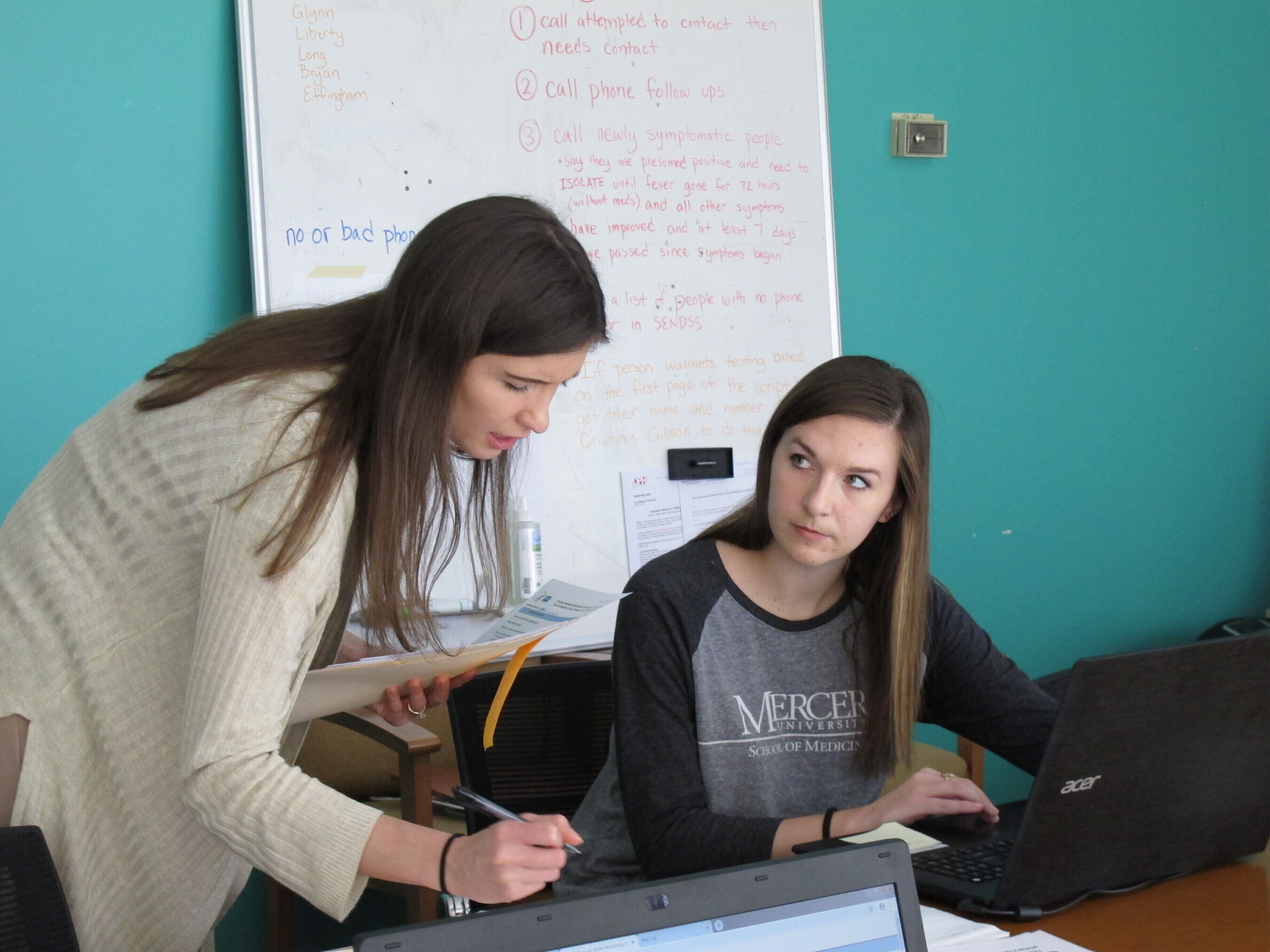 In this April 22, 2020, file photo, medical student Catherine Waldron talks with epidemiologist Elizabeth Goff at the Georgia Department of Public Health's district office in Savannah, Ga. Waldron is among about 30 medical students helping the Georgia health agency's coastal district with contact tracing aimed at identifying relatives, friends and co-workers of people infected by the virus to prevent its spread to others. (AP Photo/Russ Bynum, File)