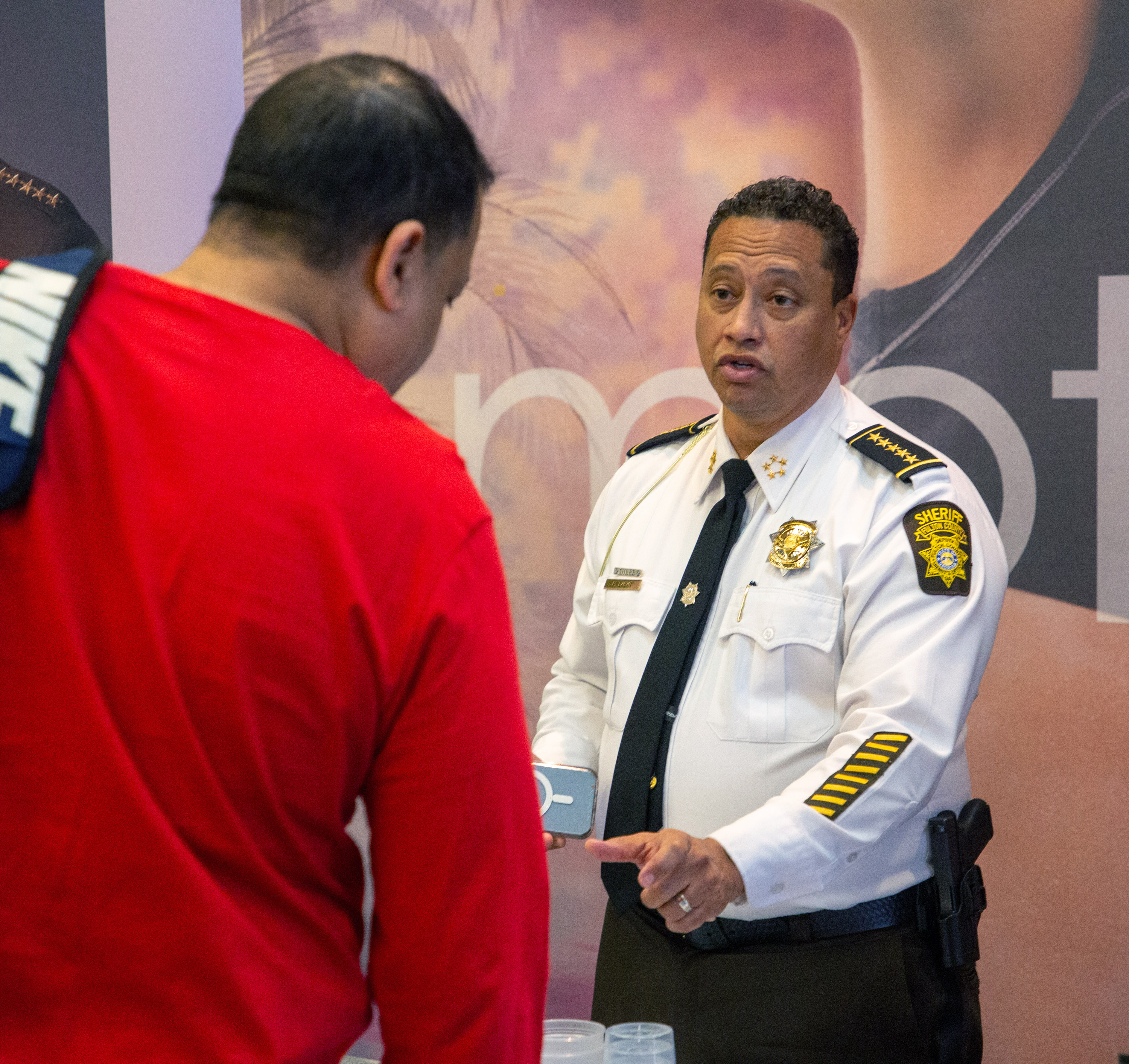 Fulton County Sheriff Patrick Labat talks to a potential recruit at a job fair at LA Fitness in Atlanta Friday, Feb. 11, 2022. STEVE SCHAEFER FOR THE ATLANTA JOURNAL-CONSTITUTION