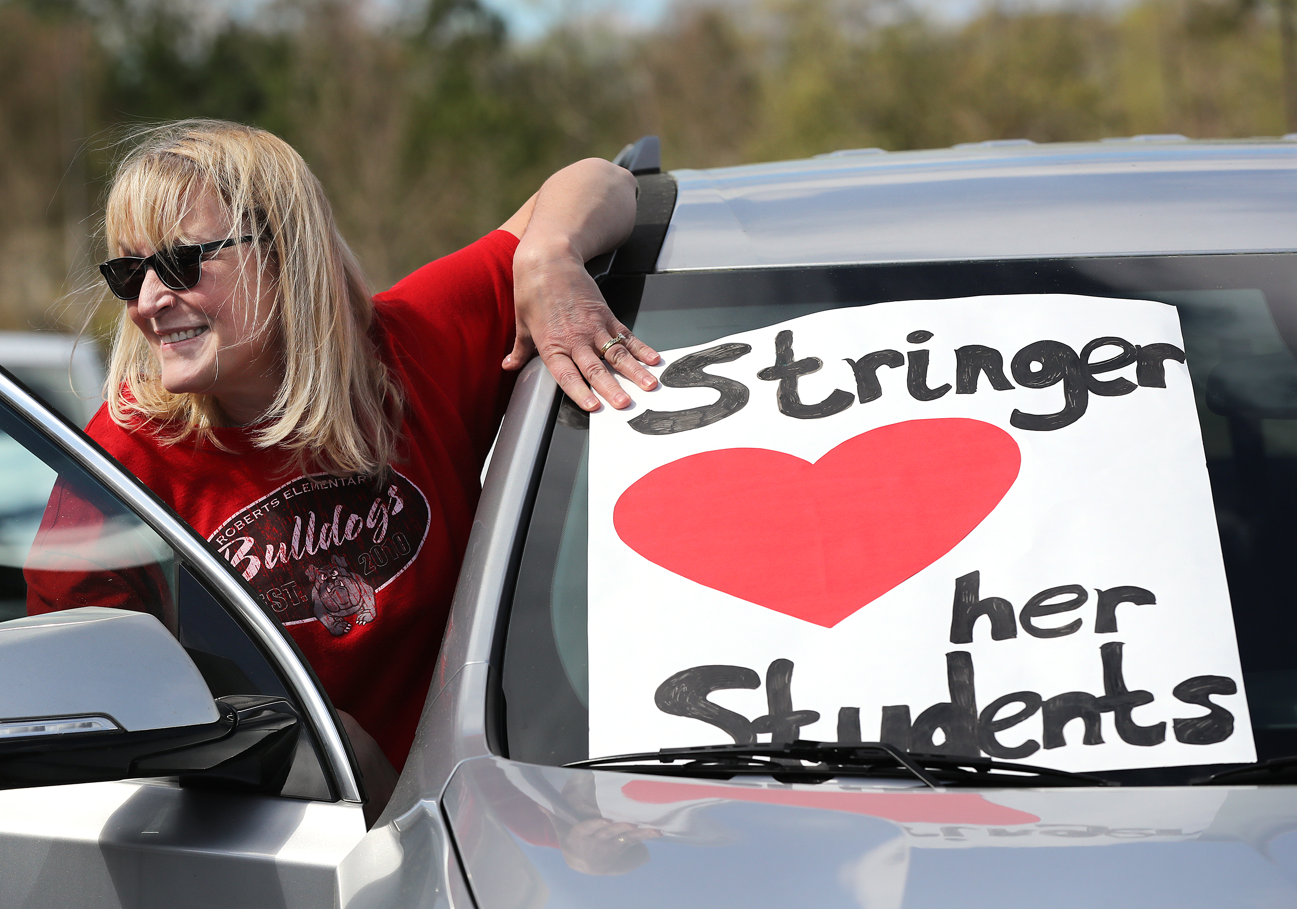 Second through fifth grade teacher Angie Stringer lets her students know she loves them while teachers from Roberts Elementary hold an inspirational school parade driving through nearly two dozen area neighborhoods for some face-to-face contact while still maintaining social distance to ease the separation anxiety of their students during the coronavirus on Wednesday, March 25, 2020, in Suwanee. Although distance learning is allowing kids to connect with teachers and get lessons done, the personal touch is missing.