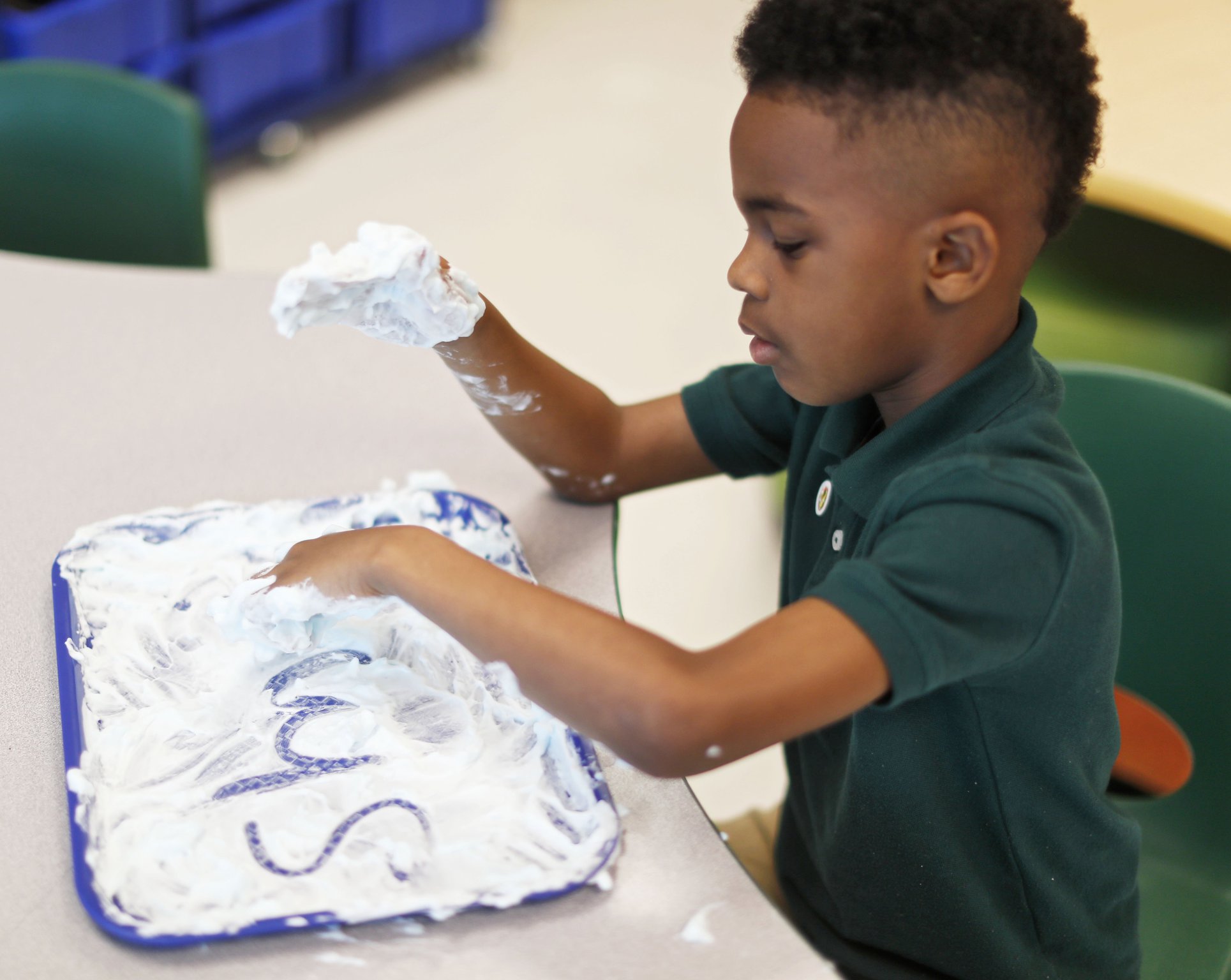 Braxton Slaughter, 7, writes in shaving cream in the literary center at Charles R. Drew Charter School on April 18, 2019. Nonsense “words” ensure students can apply phonics rules. Students at Drew who struggle with reading get the kind of “multisensory” interventions envisioned by Senate Bill 48. In addition to mandatory statewide screening for dyslexia in kindergarten, which Drew already does, the bill mandates teacher training that may look like what’s already happening at the Atlanta school.