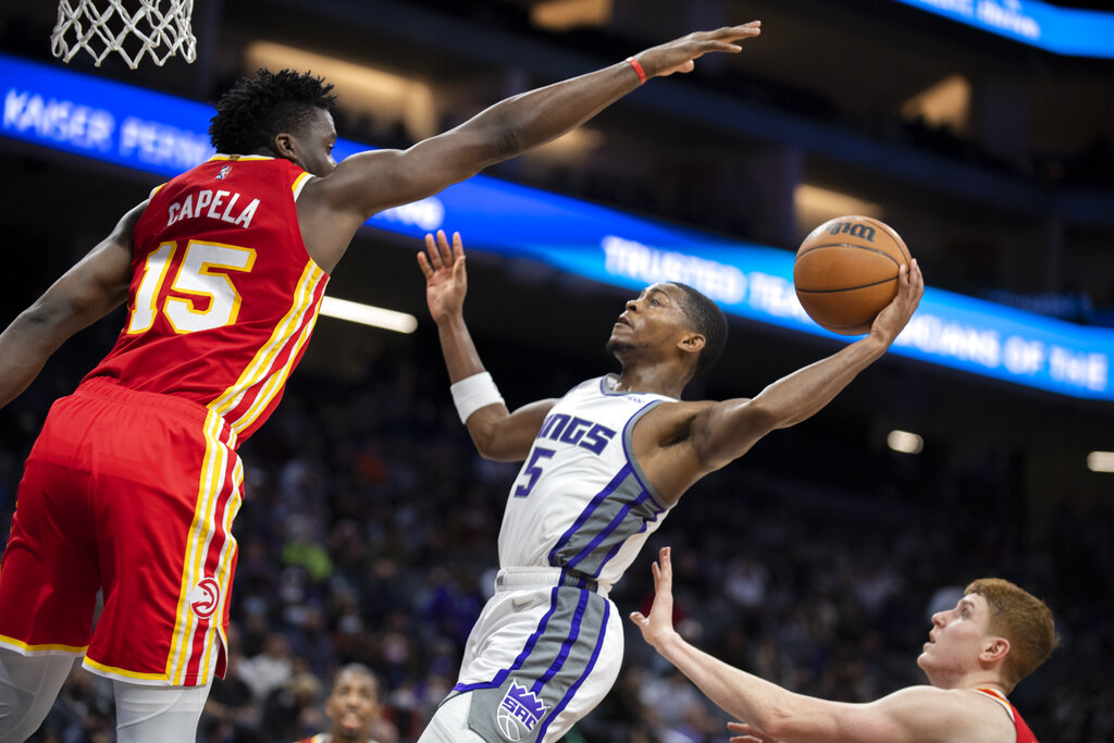 Atlanta Hawks center Clint Capela (15) defends against Sacramento Kings guard De'Aaron Fox (5) on a drive to the basket during the second half of an NBA basketball game in Sacramento, Calif., Wednesday, Jan. 5, 2022. The Hawks won 108-102. (AP Photo/José Luis Villegas)