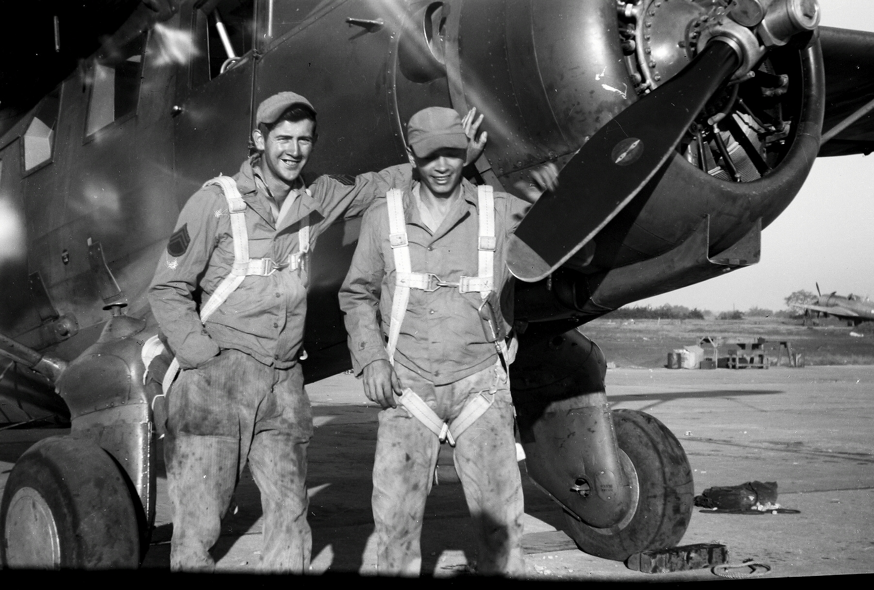 Sgt. Jim Galloway, left, in grease-stained coveralls and a parachute.