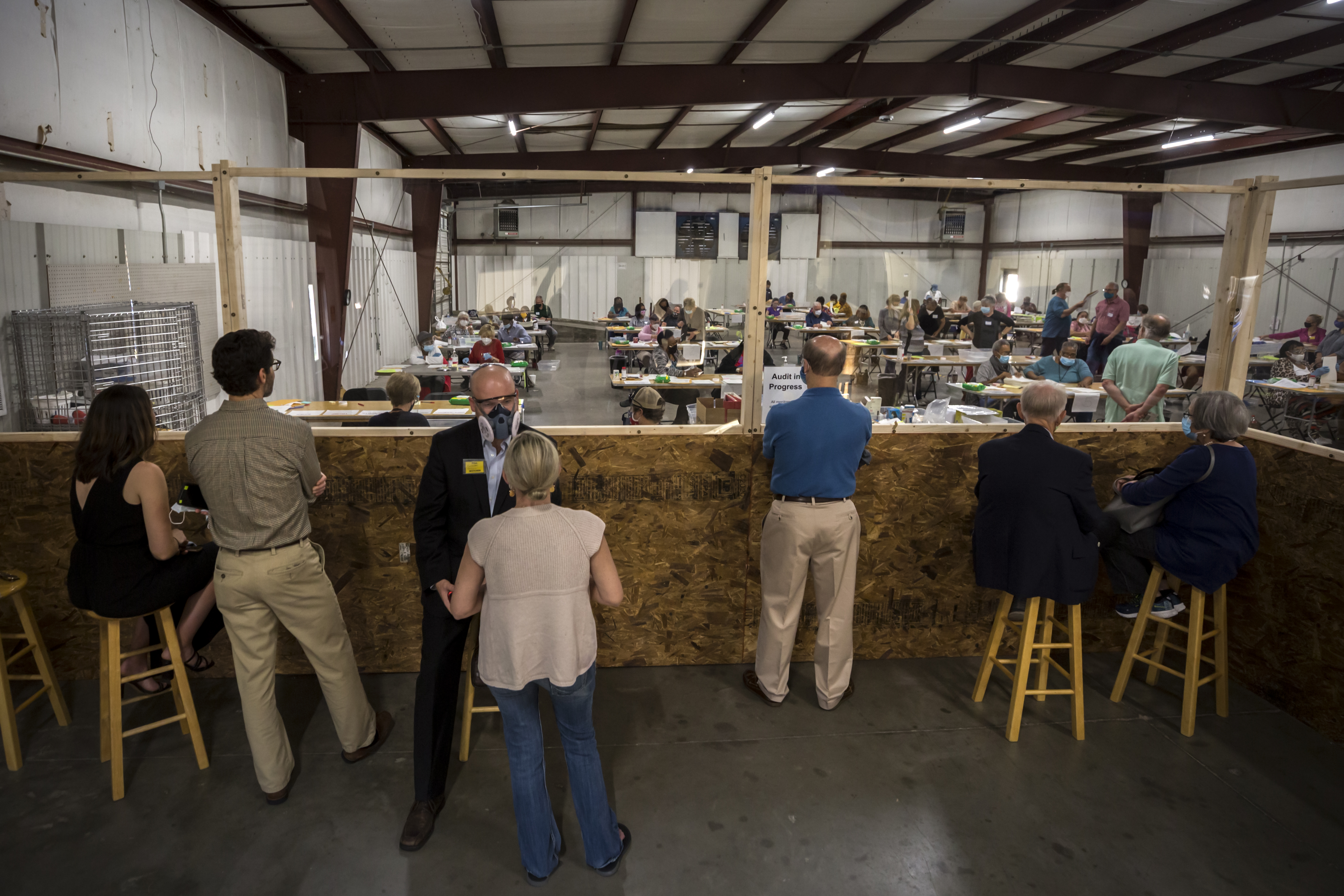 A group of poll watchers observe a hand tally of presidential race results in Savannah as part of a state audit in November. The new voting law requires training for poll watchers and grants them more access to the counting. Critics say that it weakens protections against intimidation and harassment. (AJC Photo/Stephen B. Morton)