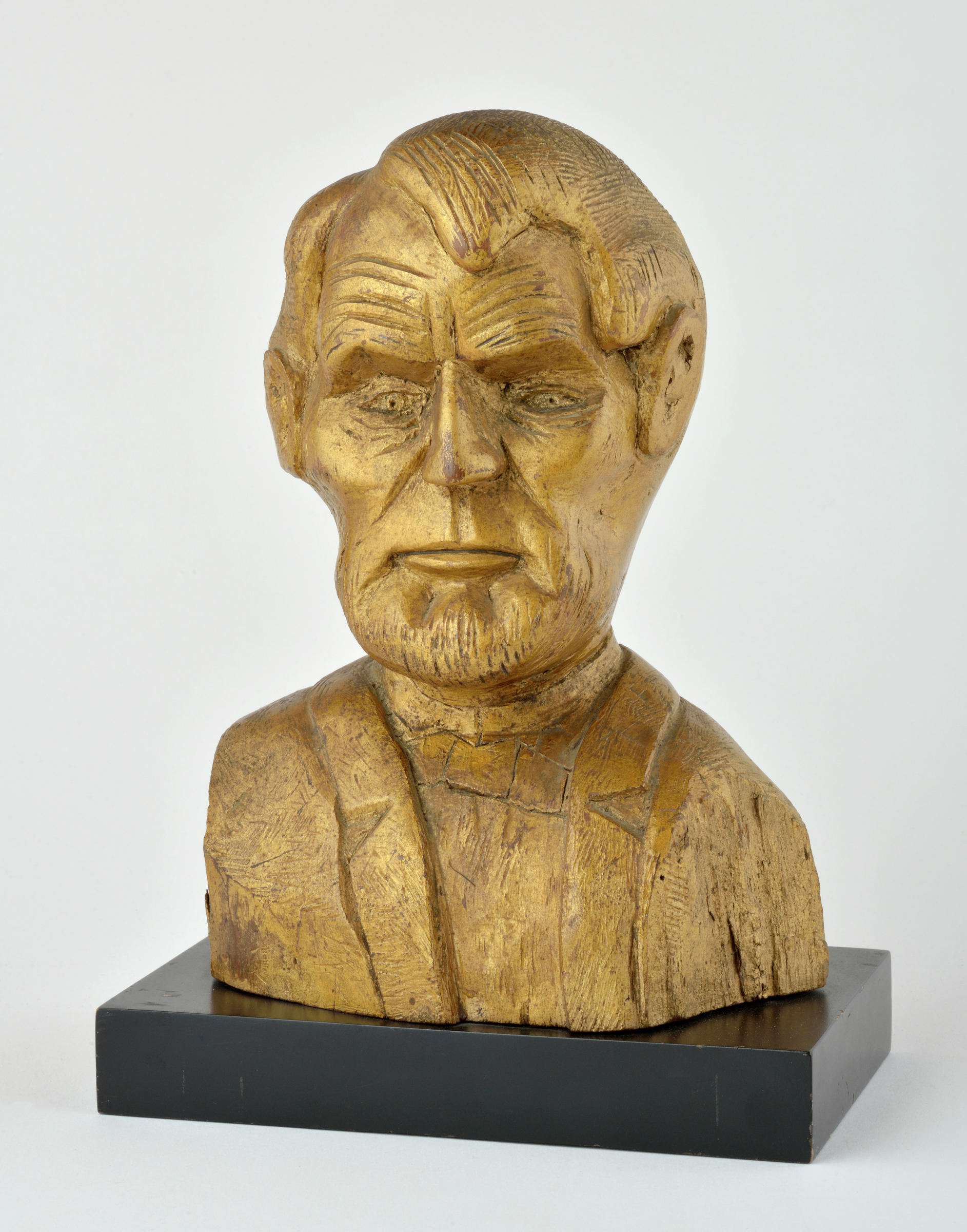 An American carved wooden bust portrait depicting Abraham Lincoln with allover gilt enrichment on ebonized base, circa early 20th century, was created by an unidentified artist. This piece is at the High Museum of Art, Atlanta, and a gift from the Levine Folk Art Collection. Courtesy of Kenneth Kast