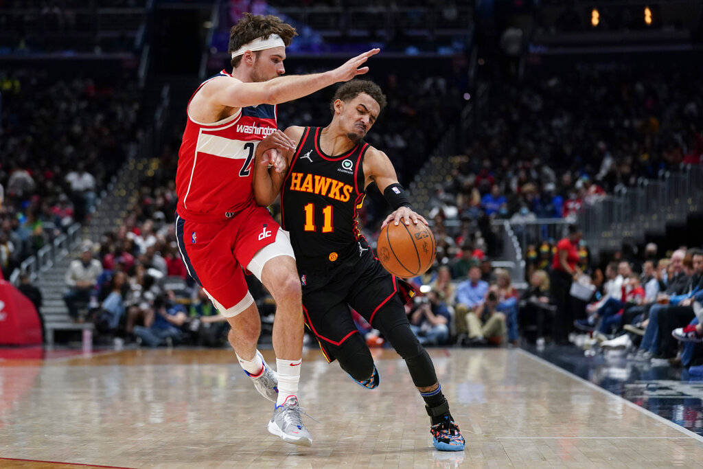 Washington Wizards forward Corey Kispert, left, defends against Atlanta Hawks guard Trae Young during the second half of an NBA basketball game, Friday, March 4, 2022, in Washington. The Hawks won 117-114. (AP Photo/Evan Vucci)