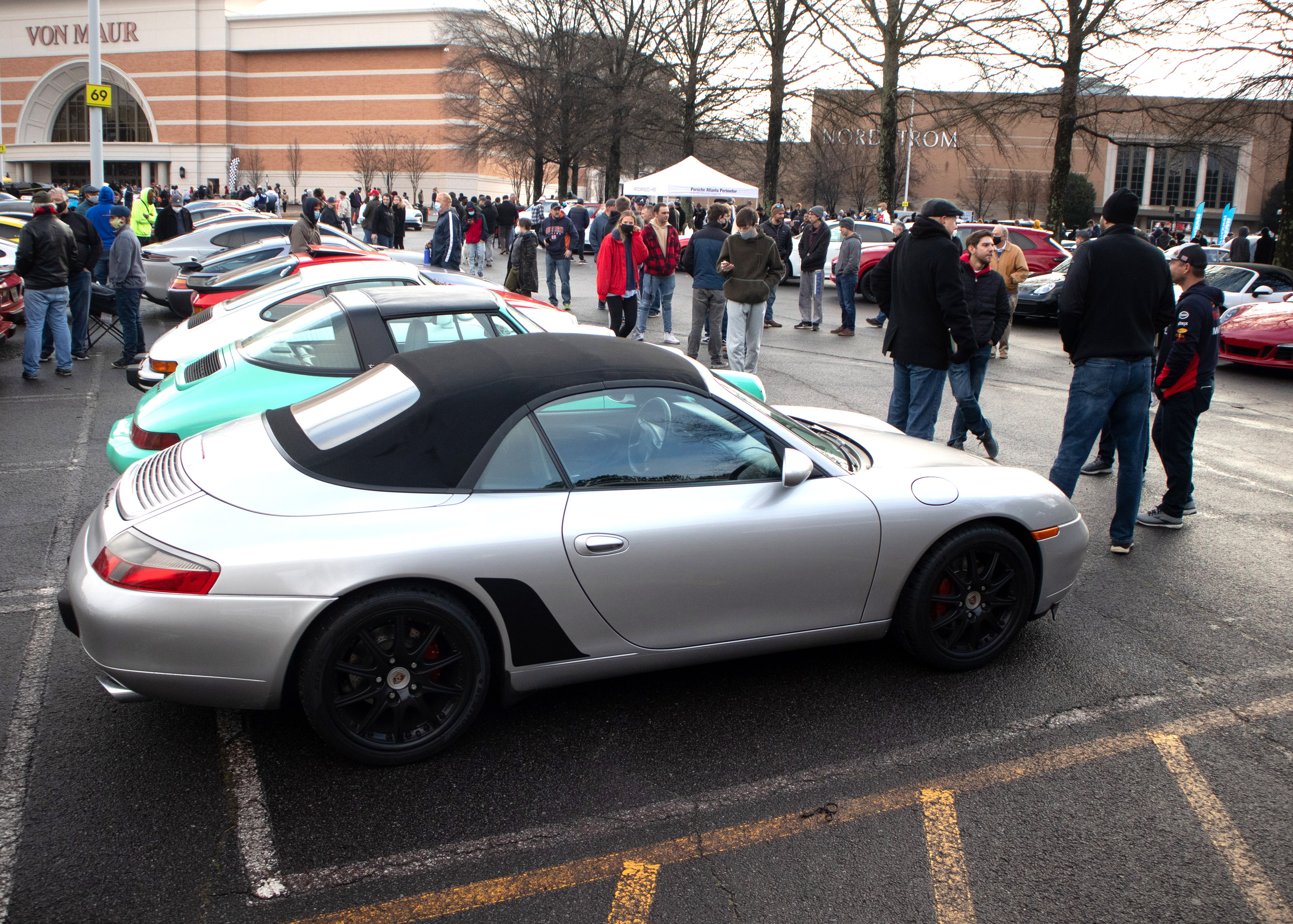 People look over the cars at the Caffeine and Octane car show at Perimeter Mall in Dunwoody on Sunday, February 7, 2021. (Photo: Steve Schaefer for The Atlanta Journal-Constitution)