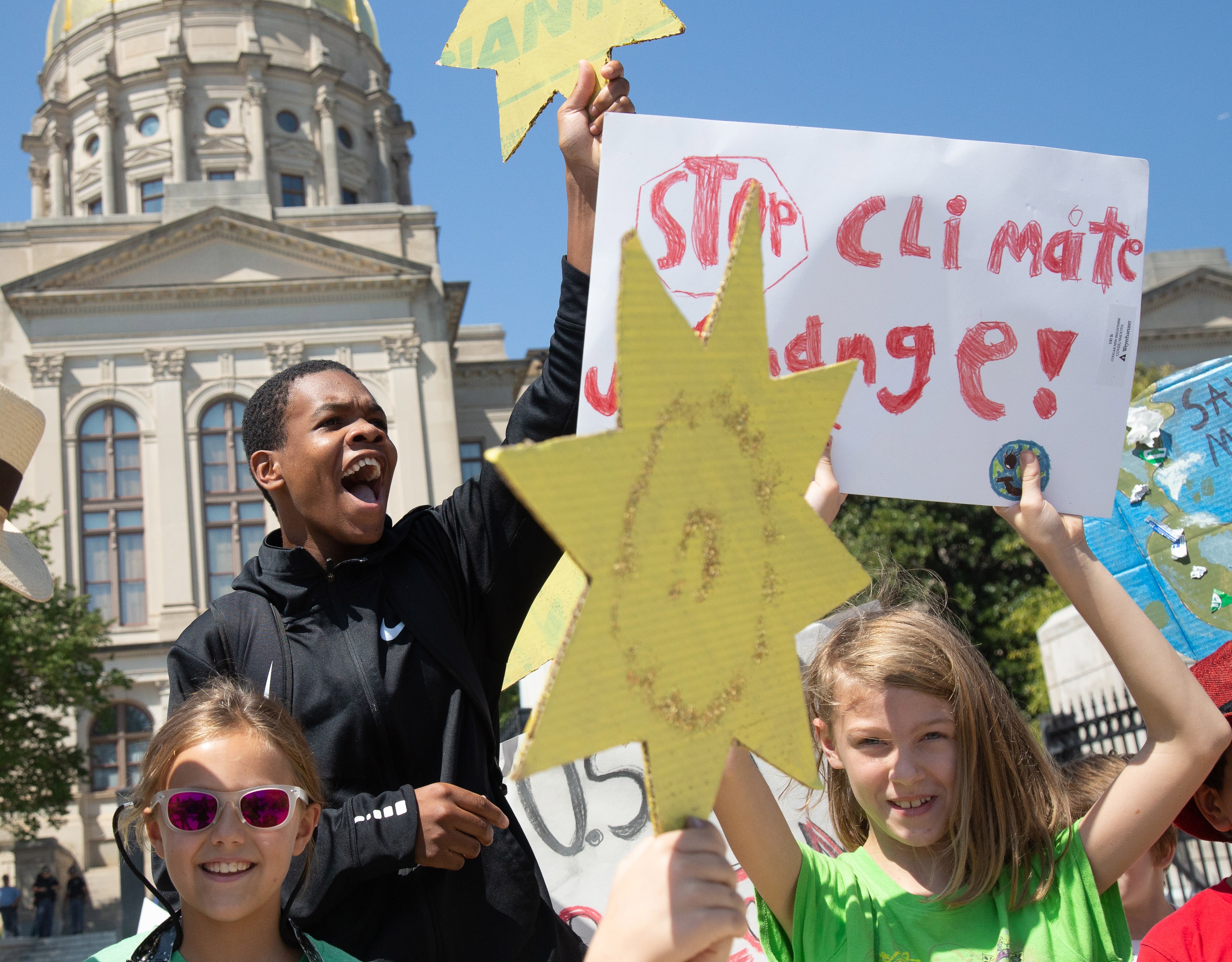 Jordan Madden (L) from Moutzion High School cheers near the Georgia Capitol during the Climate Reality Strike March Friday, September 20, 2019.