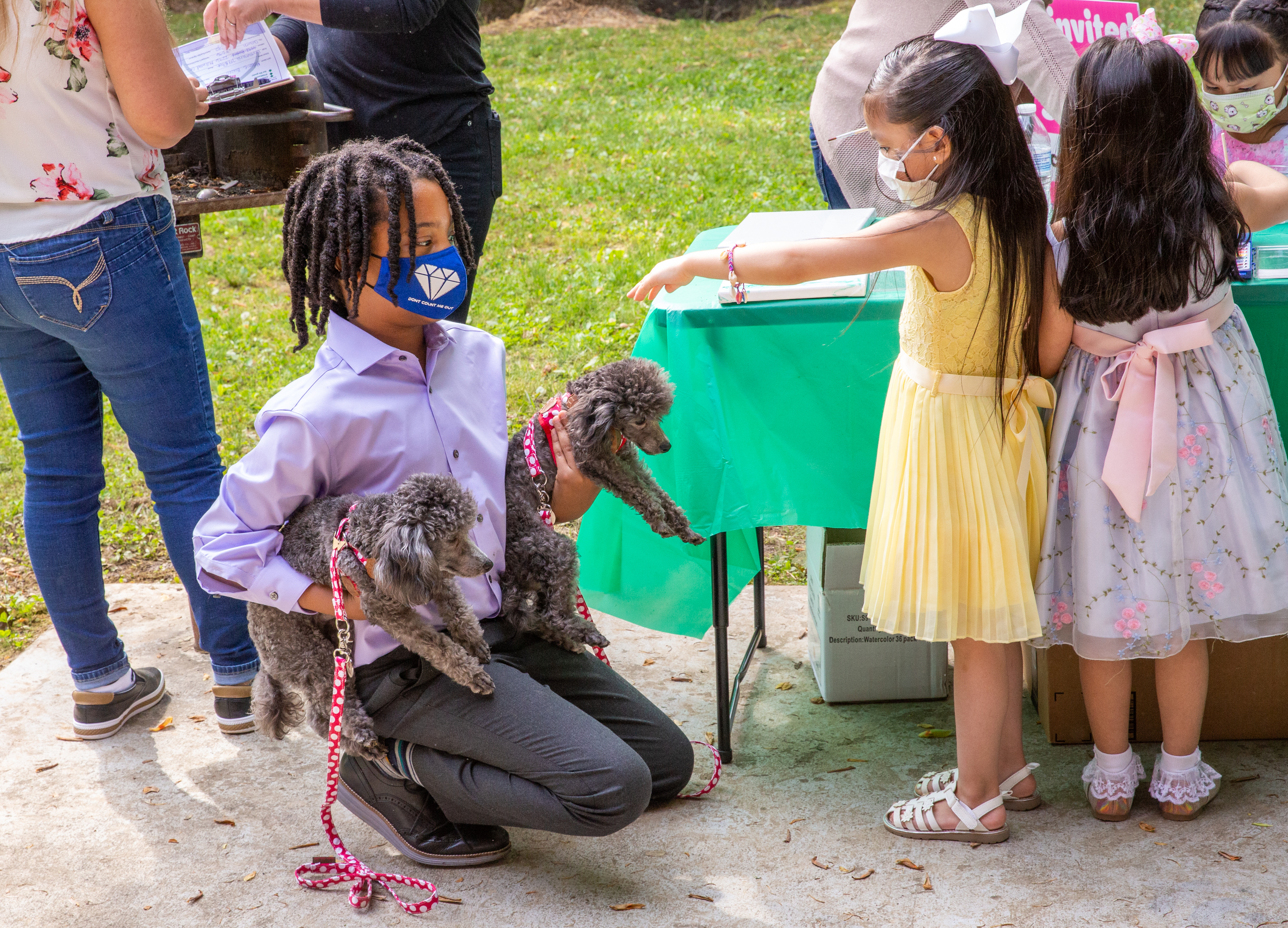 Young philanthropist, 11-year-old Malon James, left, introduces Chachi and Tutu at a Families First event in Norcross where he is giving away quality masks for free Thursday, April 29, 2021. The non-profit organization has received grant funding and is serving underprivileged communities. (Jenni Girtman for The Atlanta Journal-Constitution)