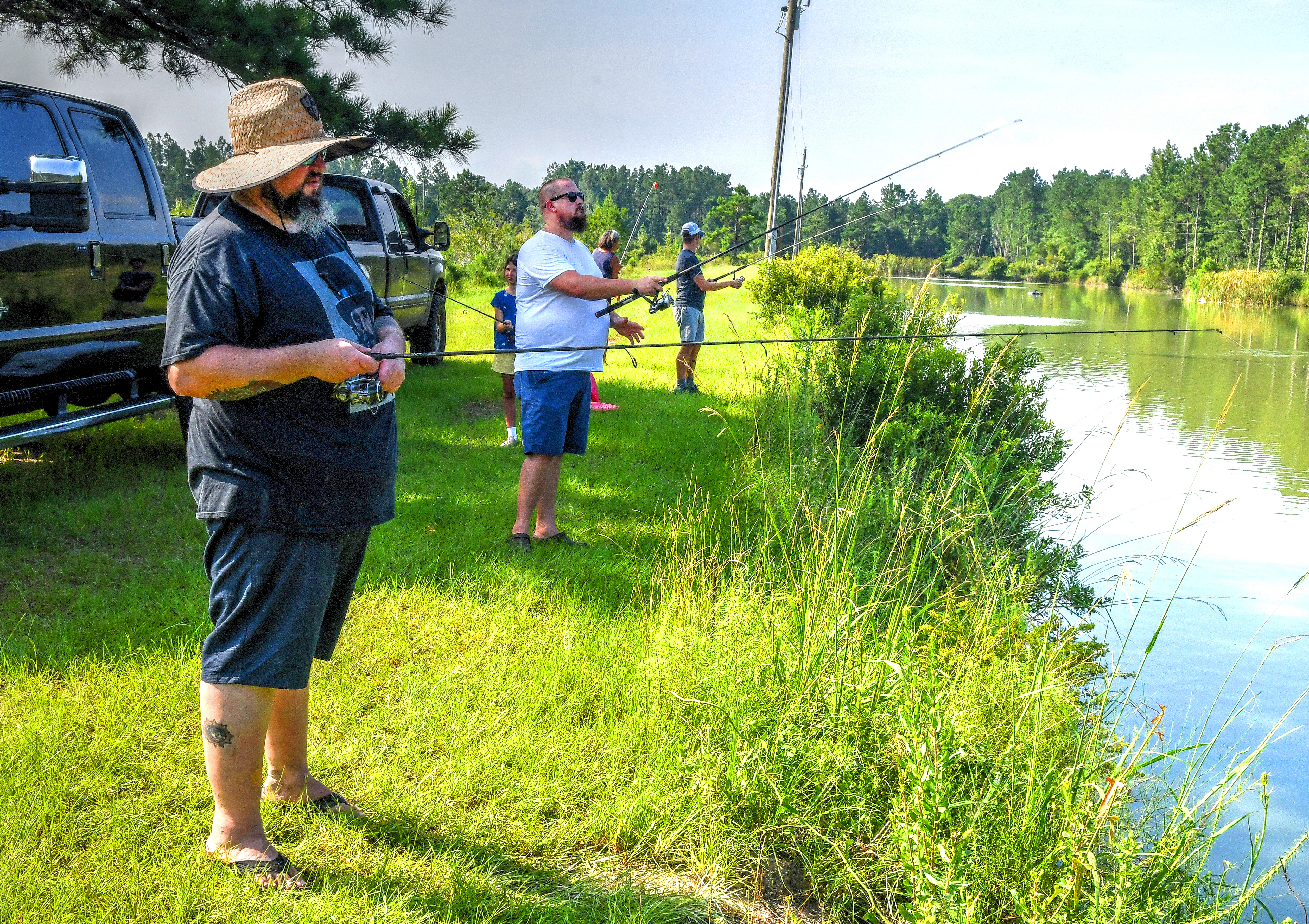 Tim Lensch (from front), Eric Miller and Zack Gowen fish for catfish at Satilla Ponds. Chris Hunt for The Atlanta Journal-Constitution
