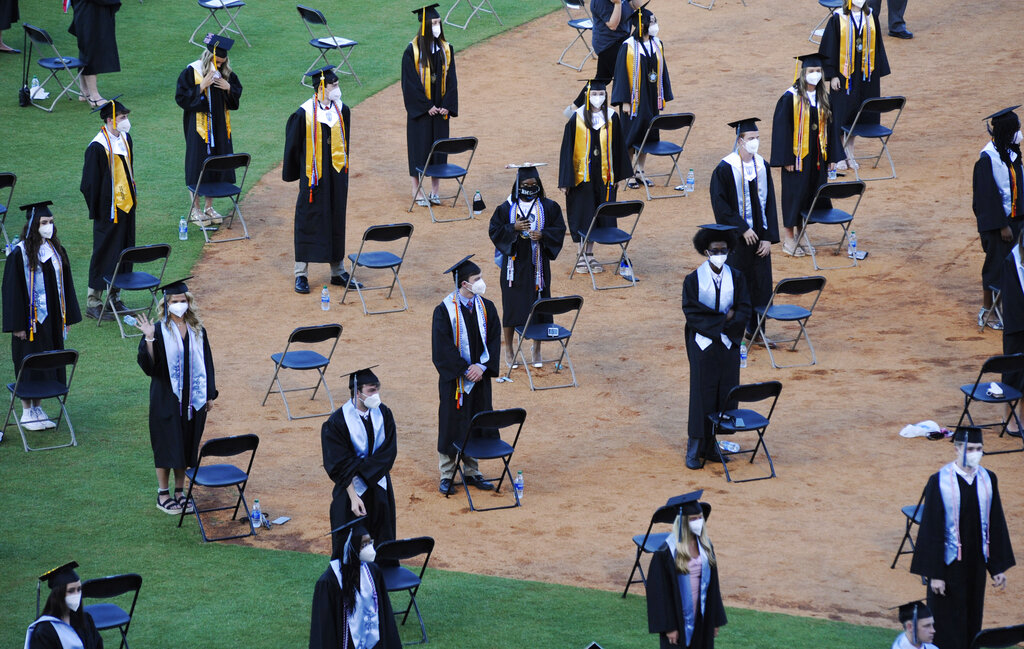 Seniors from Spain Park High School stand on a baseball field at a socially distanced graduation ceremony in Hoover, Ala., Wednesday, May 20, 2020. Health officials say usual graduation ceremonies could endanger the public health by promoting the spread of disease. But school officials say they're using social distancing guidelines and abiding by state health rules. (AP Photo/Jay Reeves)