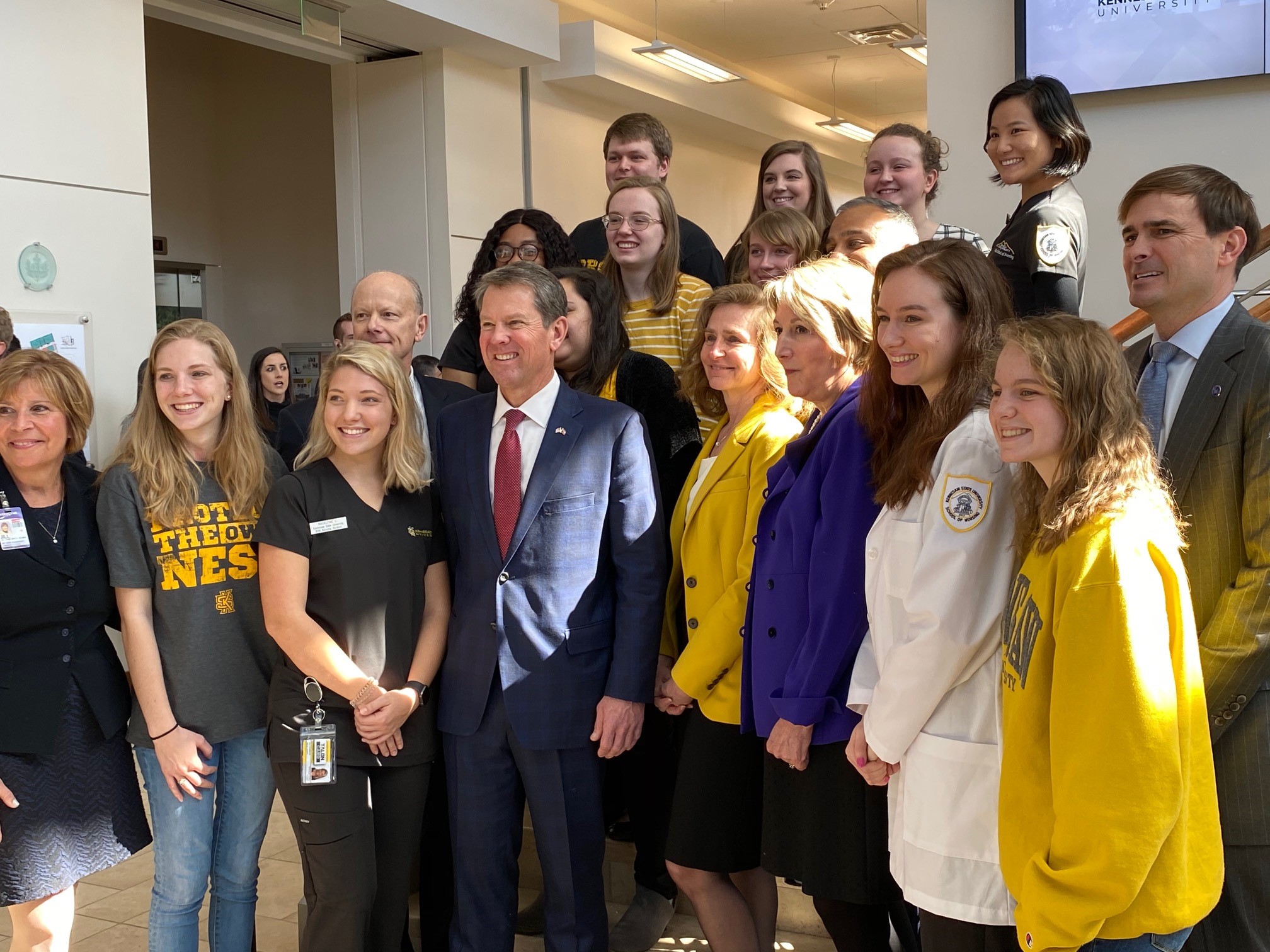 Georgia Gov. Brian Kemp (center in the front row) is joined by Kennesaw State University students and other officials after an announcement by Wellstar Health System that it is donating $8.7 million to the university's nursing program.