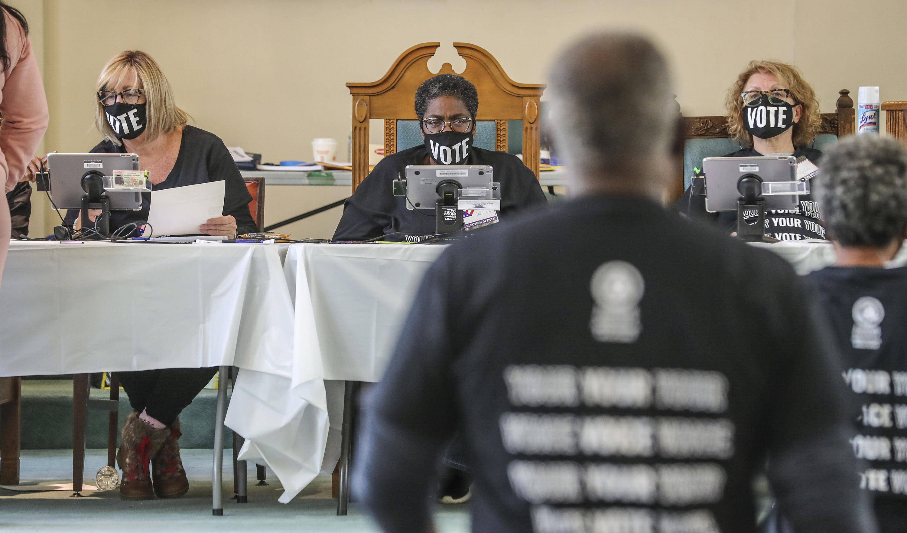 From left, poll workers Beth Claimo, Teresa Johnson and Karin Mueller wear masks and wait on voters to approach their table at Butler Street Baptist Church at 315 Ralph McGill Boulevard NE in Atlanta, Georgia on Tuesday, Nov. 3, 2020. (John Spink/Atlanta Journal-Constitution/TNS)