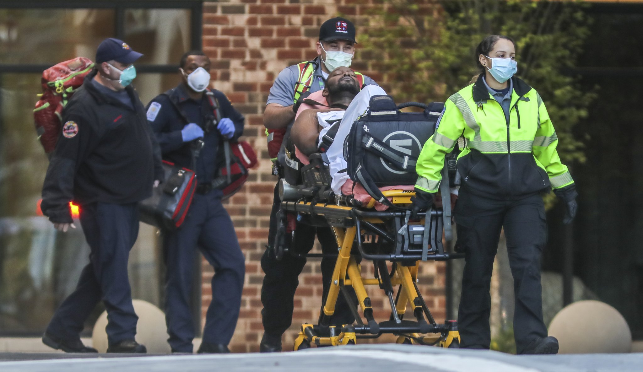 Because of the coronavirus outbreak, Atlanta Fire Rescue paramedics (left) and Grady ambulance crews (right) take extra precautions with gloves and masks during every medical call to which they respond. This call on Wednesday, April 15, 2020, was for a man unconscious in the 900 block of Huff Road at Westside Heights, according to Sgt. Cortez Stafford, public information officer for Atlanta Fire Rescue. JOHN SPINK/JSPINK@AJC.COM
