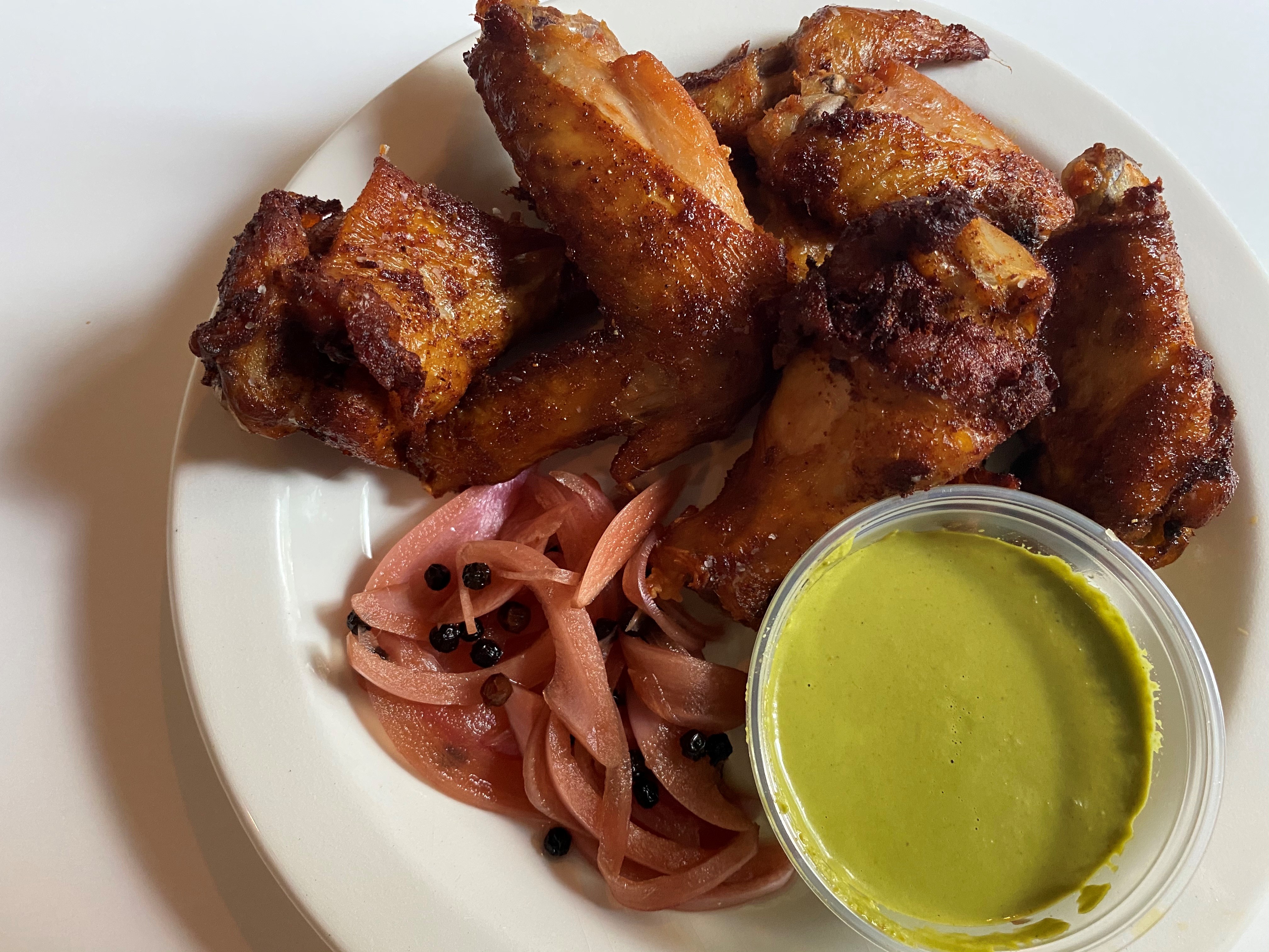 Seven Lamps offers wings that are smoked, then fried, with pickled red onion, cilantro and aji verde. CONTRIBUTED BY BOB TOWNSEND